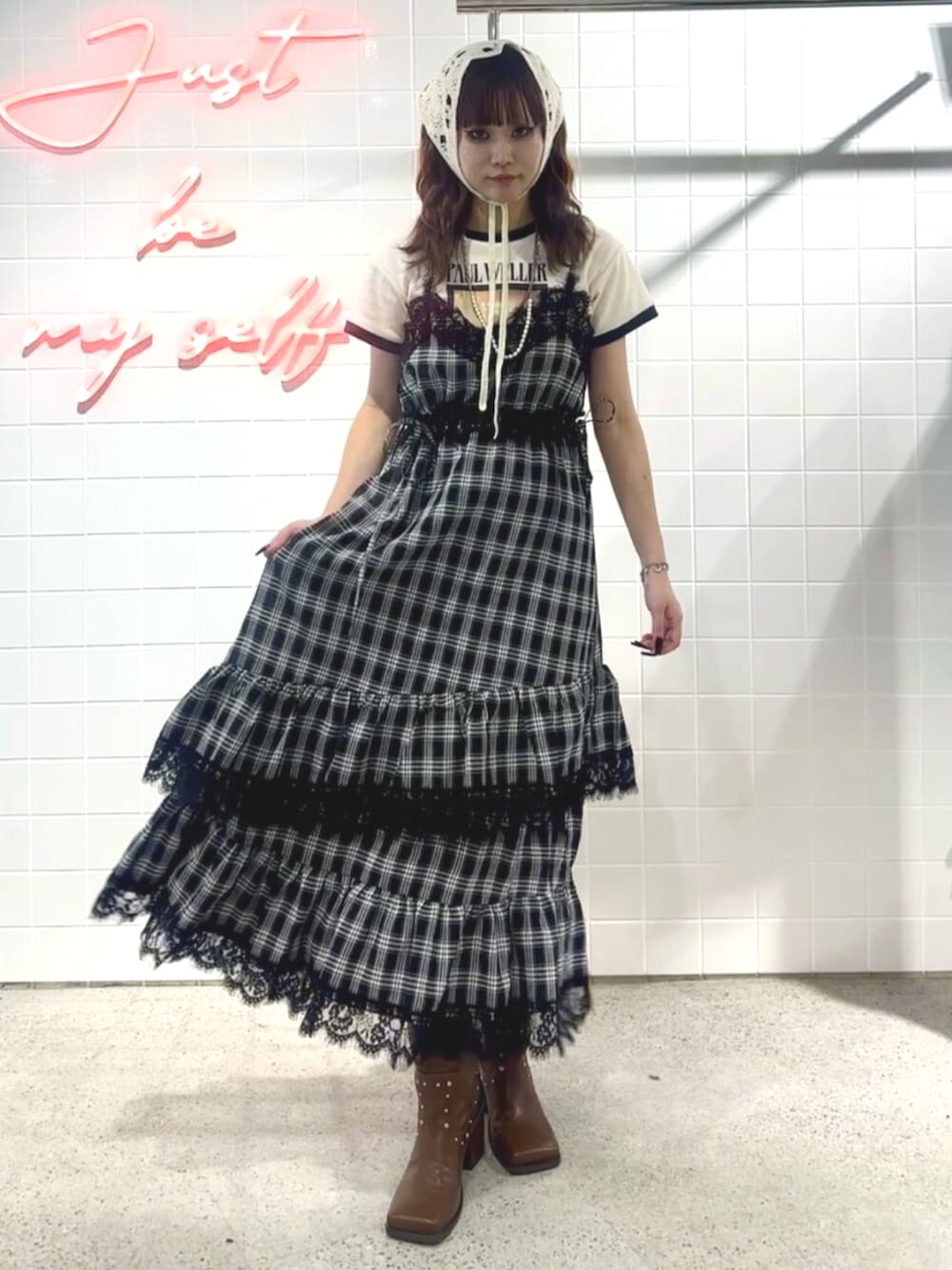 ブラック系のブーツ、ブラック系のワンピース、ホワイト系のTシャツ/カットソーを着用したレディースの夏コーディネートの2枚目の写真