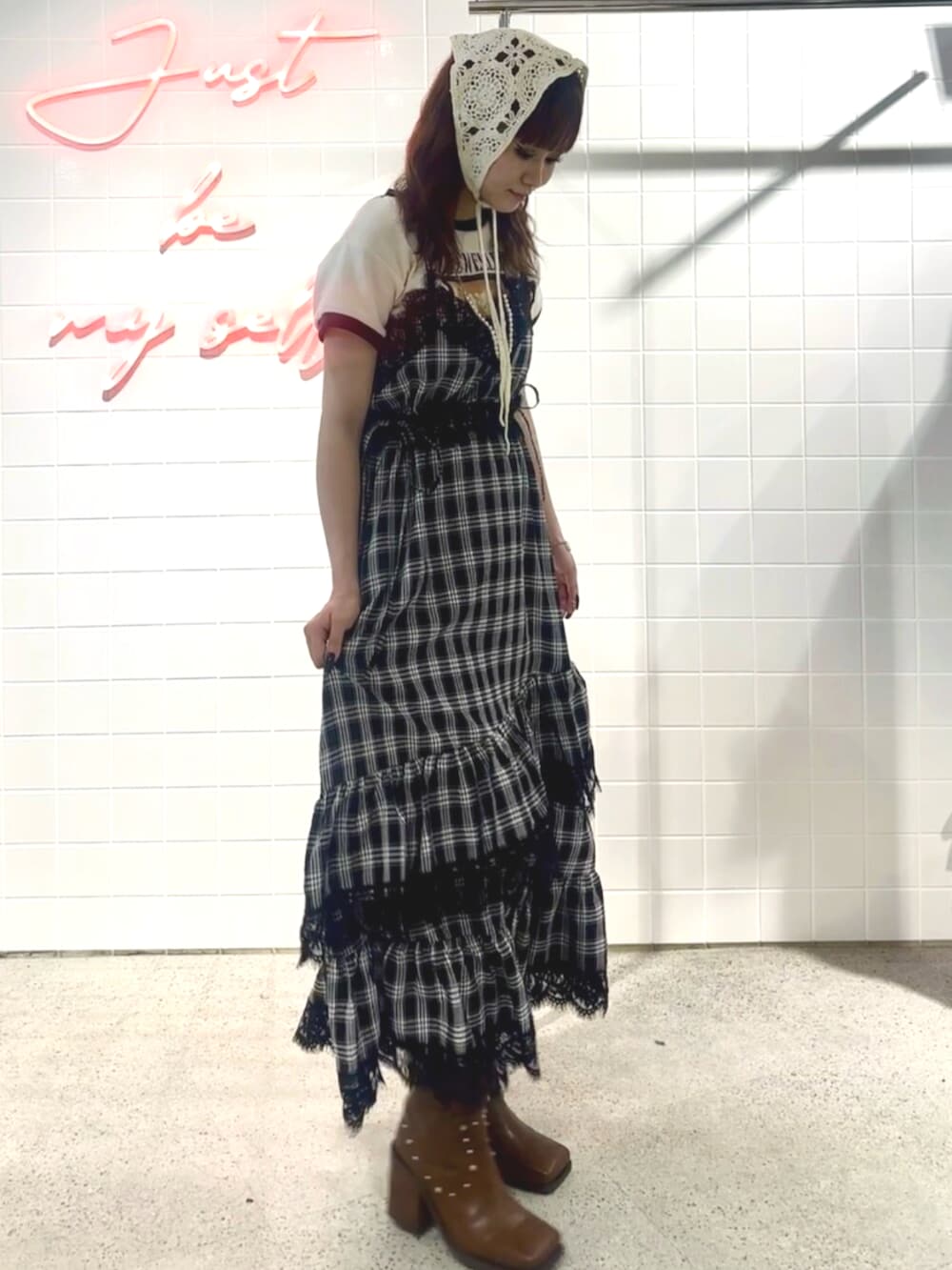 ブラック系のブーツ、ブラック系のワンピース、ホワイト系のTシャツ/カットソーを着用したレディースの夏コーディネートの4枚目の写真