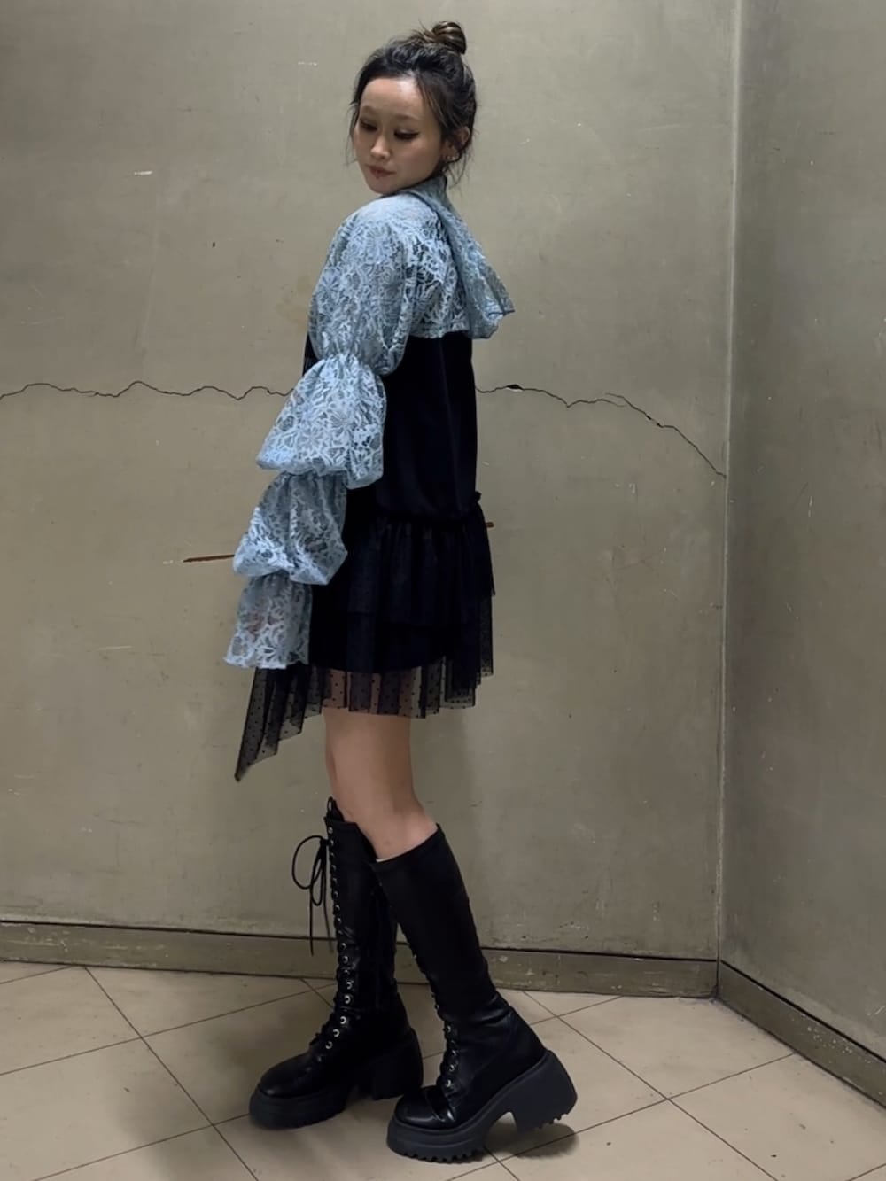 ブラック系のブーツ、ブラック系のワンピース、ブルー系のカーディガン/ボレロを着用したレディースの春コーディネートの3枚目の写真