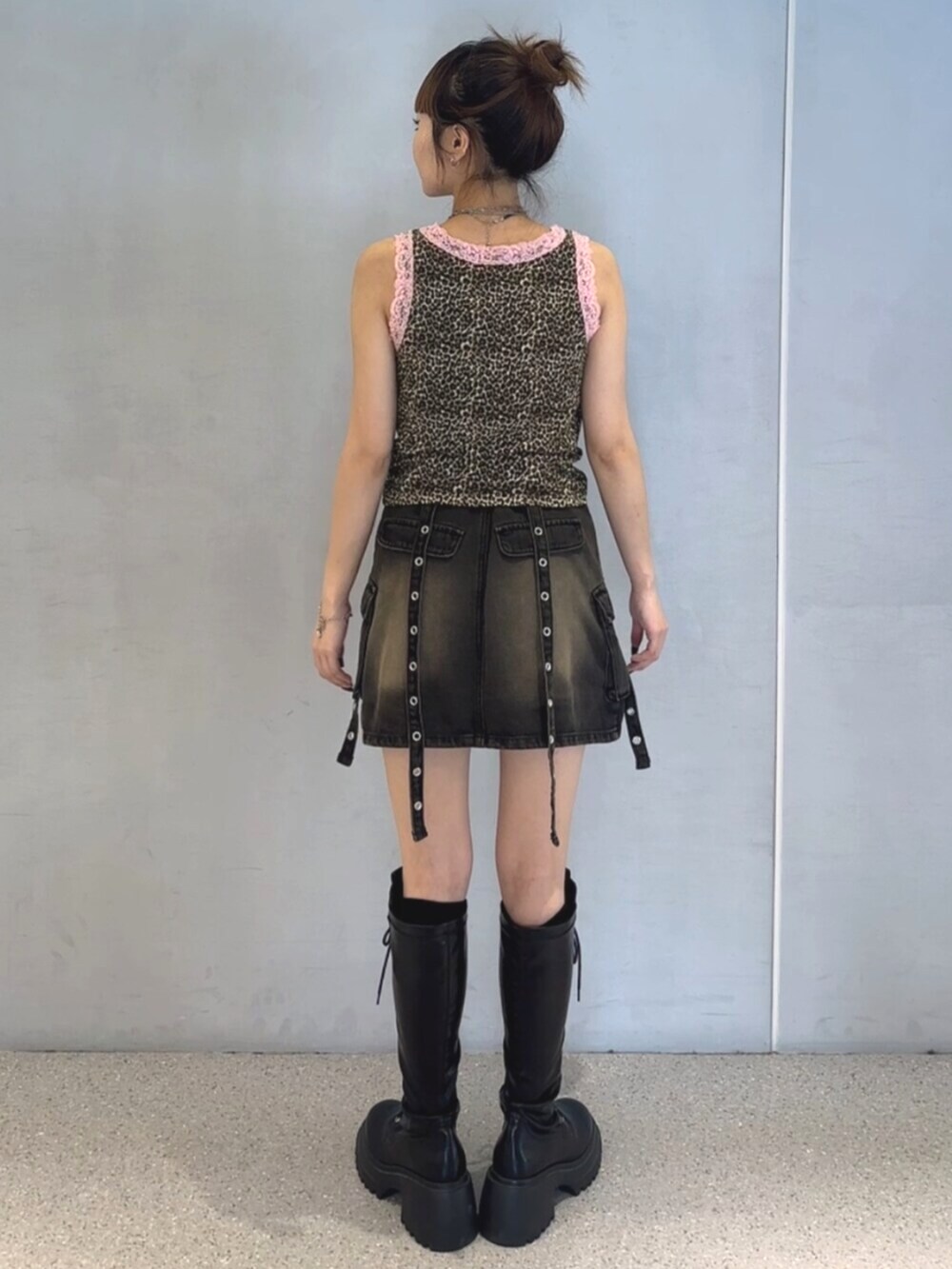 ブラック系のブーツ、ブラウン系のタンクトップ、ブラック系のスカートを着用したレディースの夏コーディネートの5枚目の写真