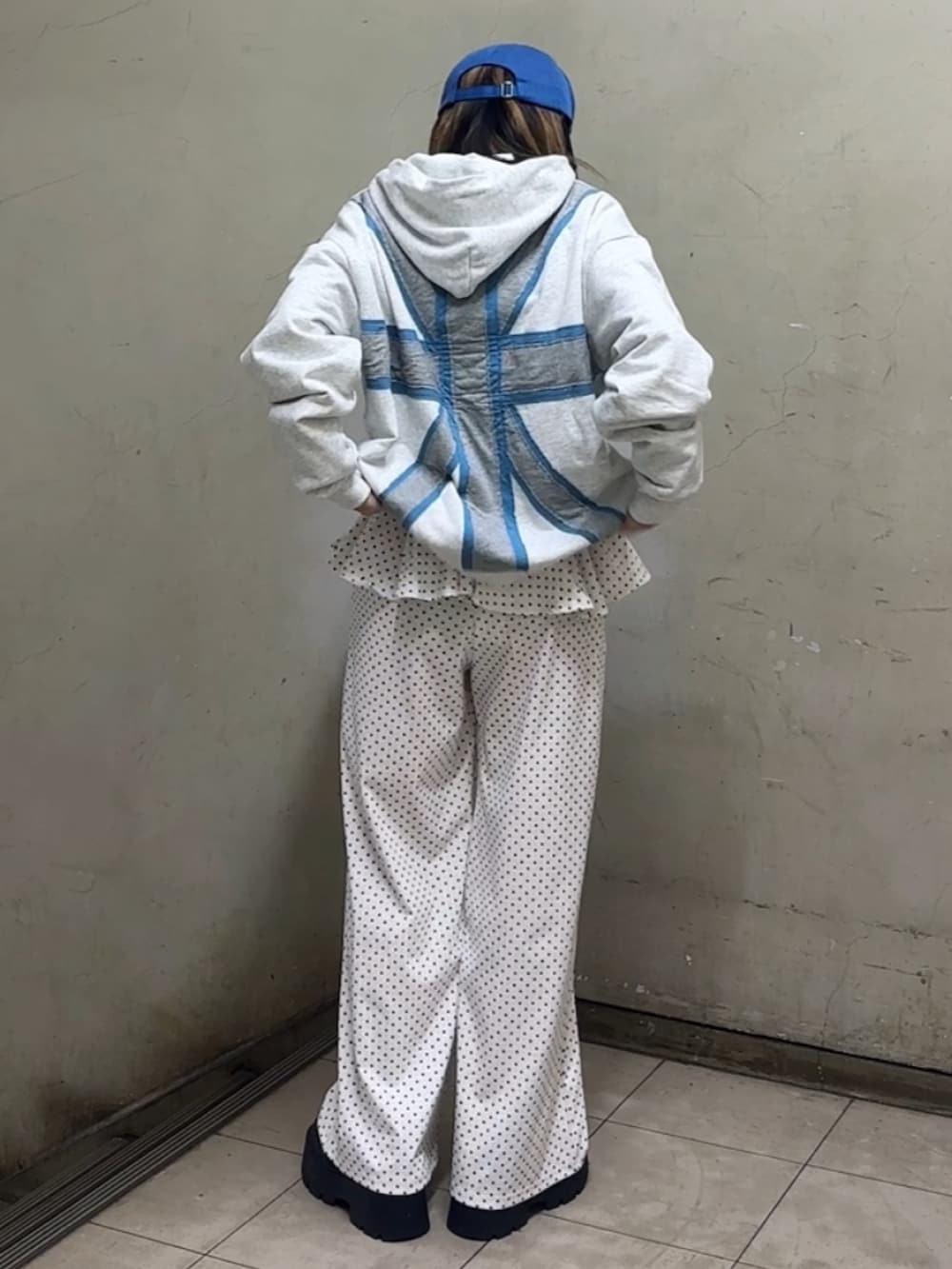 ホワイト系のパーカー、ブルー系のローファー、ホワイト系のスウェットパンツを着用したレディースの春コーディネートの5枚目の写真