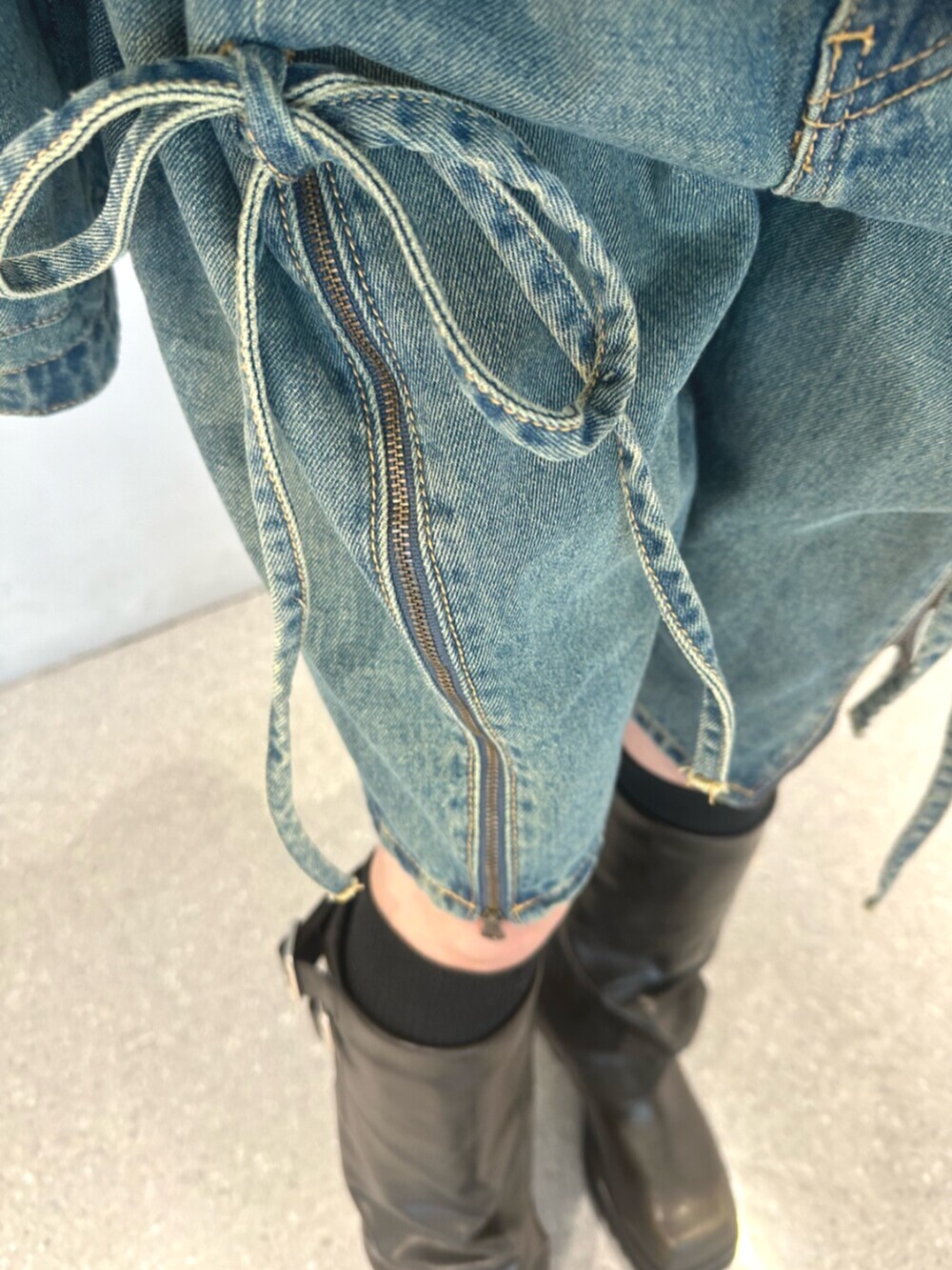 ブラック系のブーツ、ブルー系のデニムパンツ、ブラック系のTシャツ/カットソーを着用したレディースの夏コーディネートの9枚目の写真