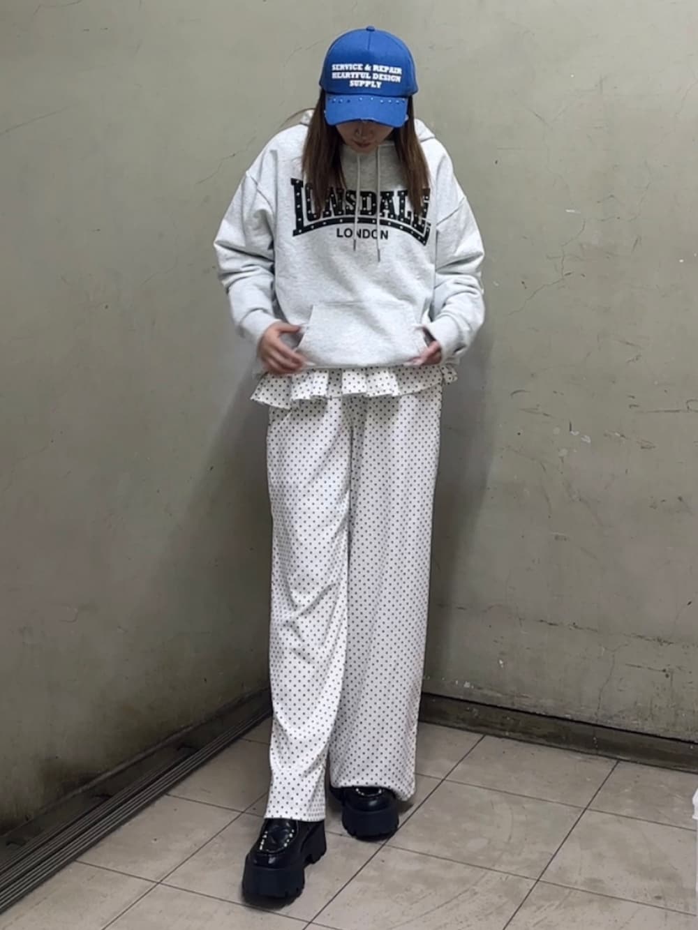 ホワイト系のパーカー、ブルー系のローファー、ホワイト系のスウェットパンツを着用したレディースの春コーディネートの3枚目の写真