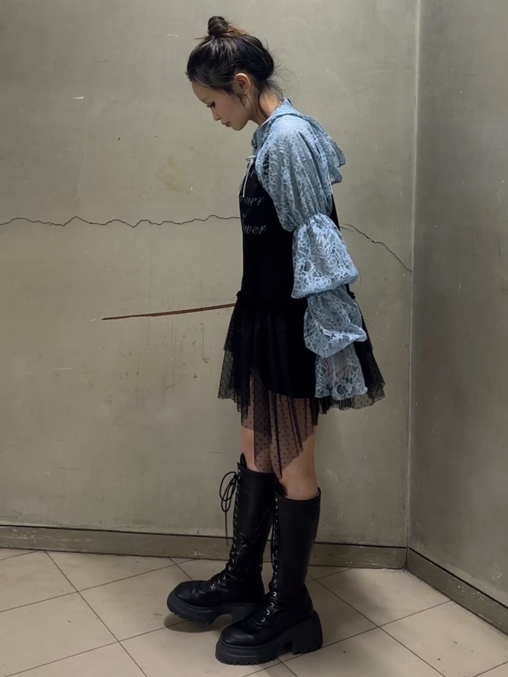 ブラック系のブーツ、ブラック系のワンピース、ブルー系のカーディガン/ボレロを着用したレディースの春コーディネートの4枚目の写真