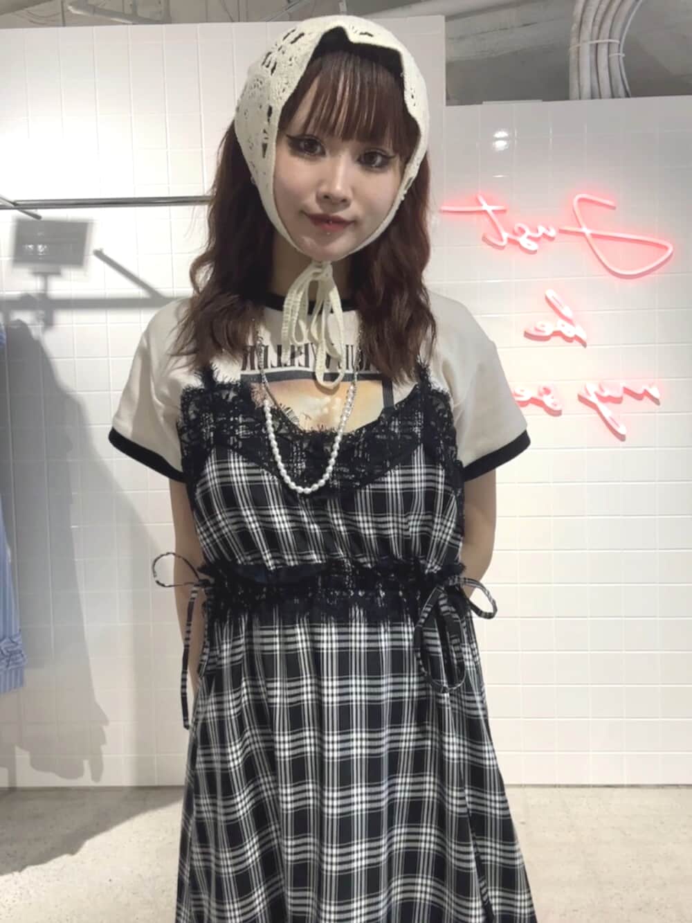 ブラック系のブーツ、ブラック系のワンピース、ホワイト系のTシャツ/カットソーを着用したレディースの夏コーディネートの6枚目の写真