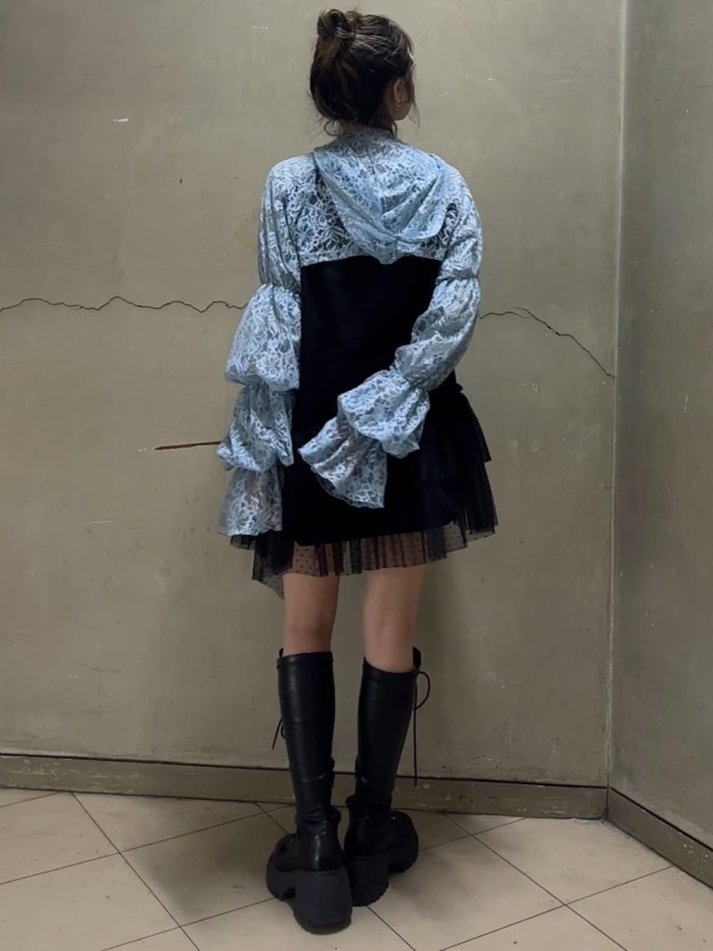 ブラック系のブーツ、ブラック系のワンピース、ブルー系のカーディガン/ボレロを着用したレディースの春コーディネートの5枚目の写真