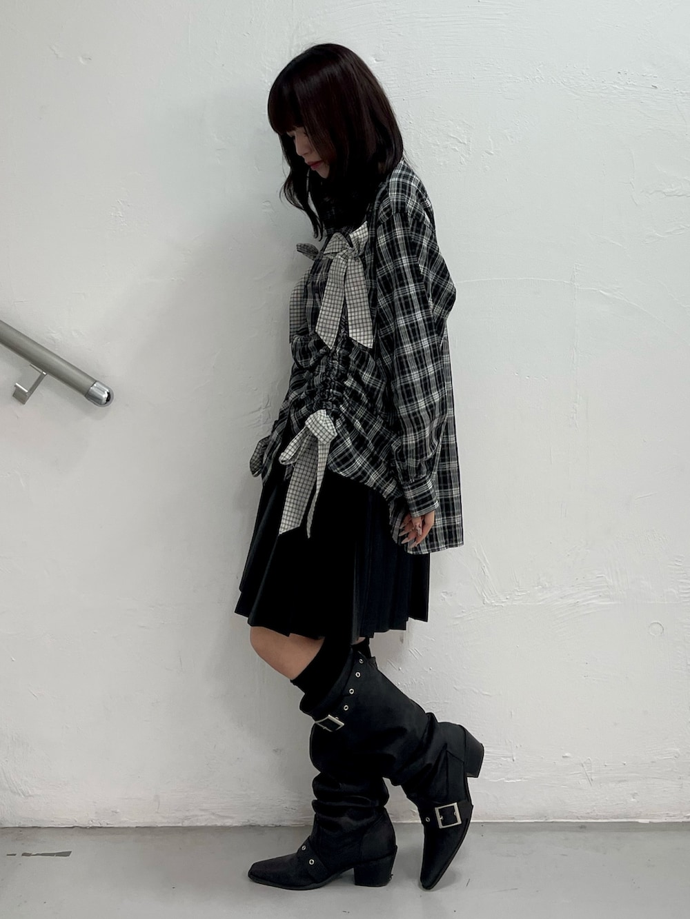 ブラック系のシャツ/ブラウス、ブラック系のスカート、ブラック系のブーツを着用したレディースの春コーディネートの3枚目の写真