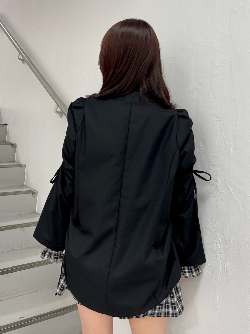 ブラック系のテーラードジャケット、ブラック系のワンピース、ブラック系のブーツを着用したレディースの冬コーディネートの7枚目の写真