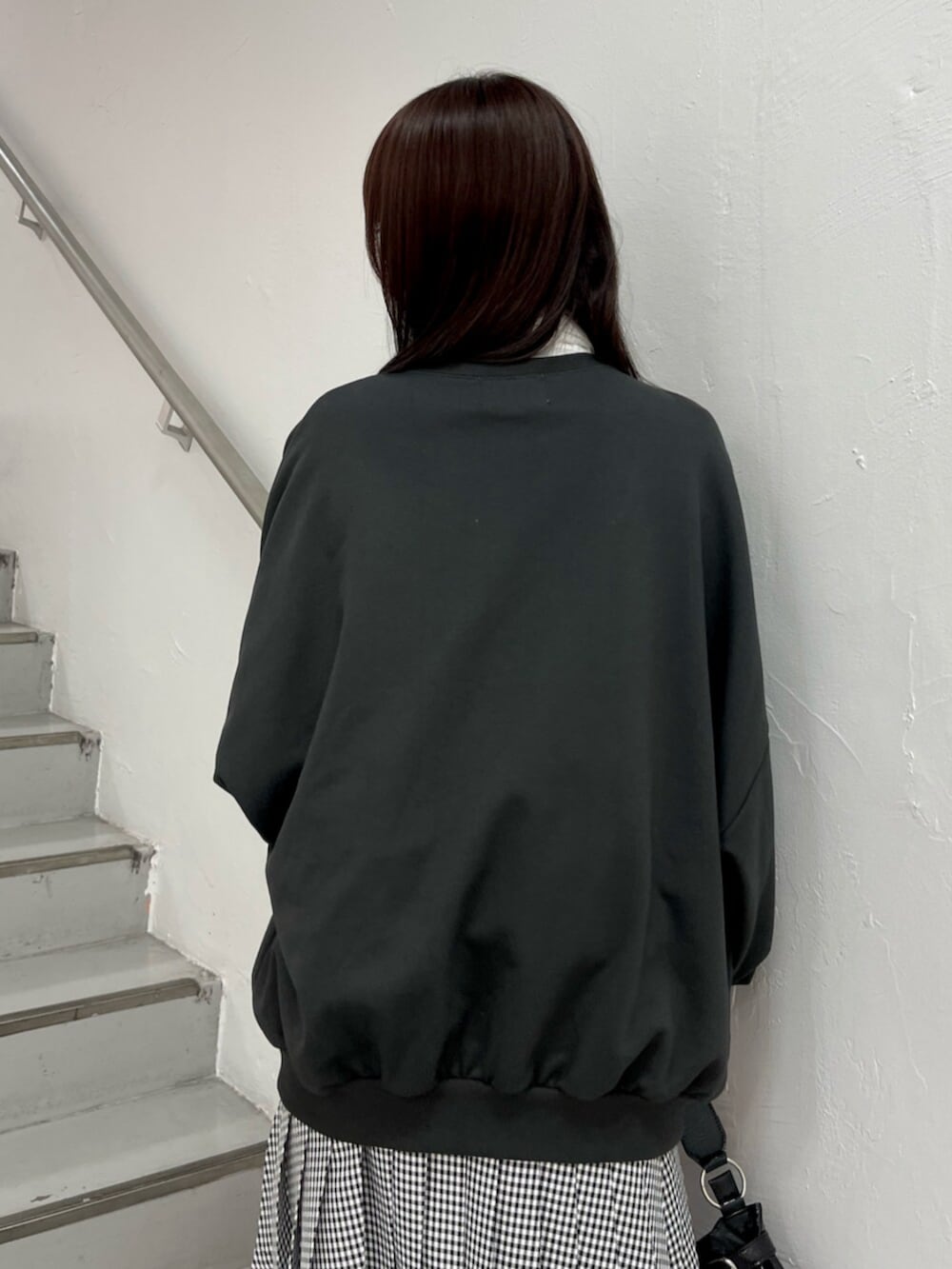 ブラック系のハンドバッグ、ブラック系のブーツ、ホワイト系のシャツ/ブラウスを着用したレディースの冬コーディネートの7枚目の写真