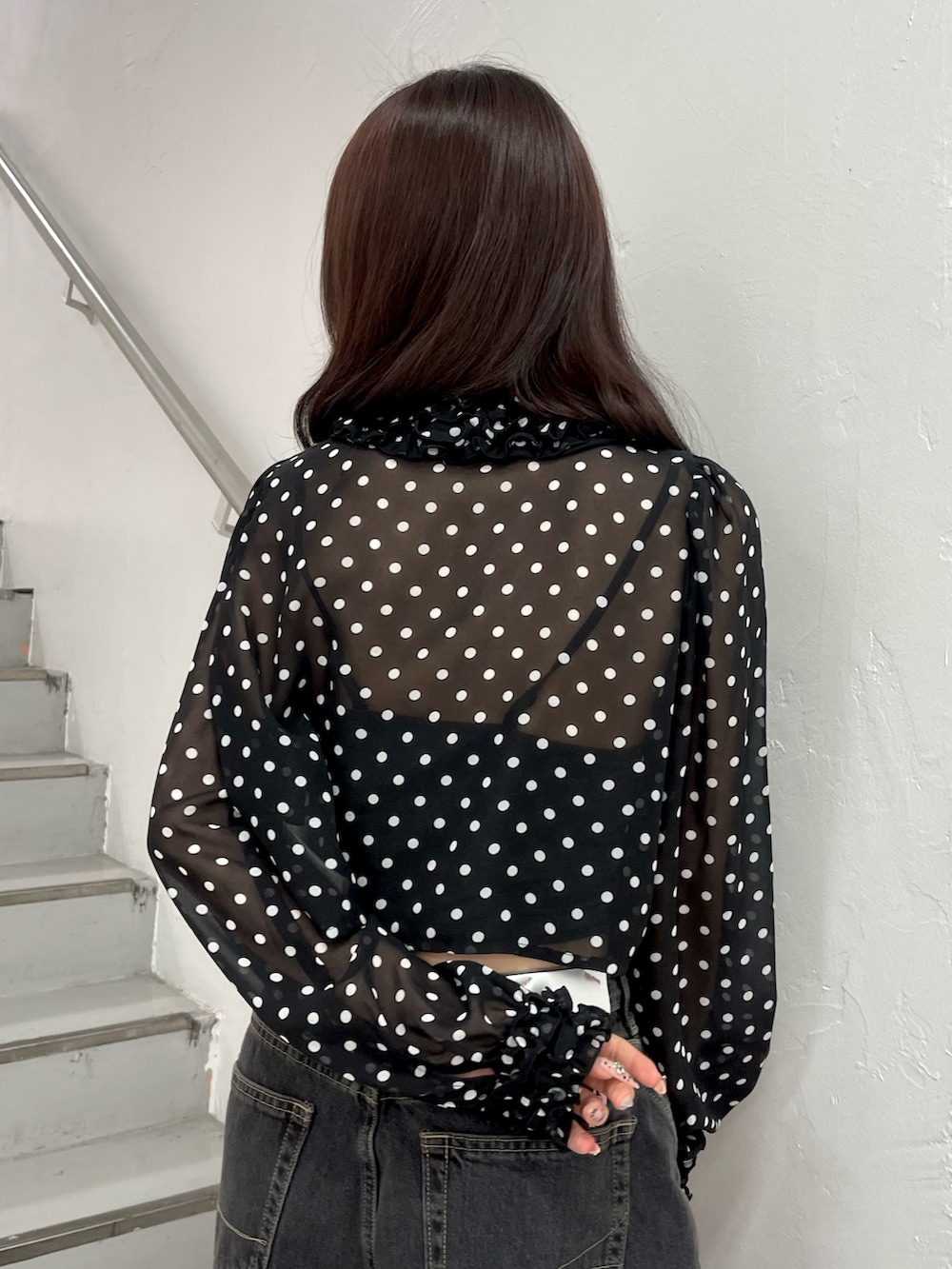 ブラック系のデニムパンツ、ブラック系のハンドバッグ、ブラック系のパンプスを着用したレディースの春コーディネートの7枚目の写真