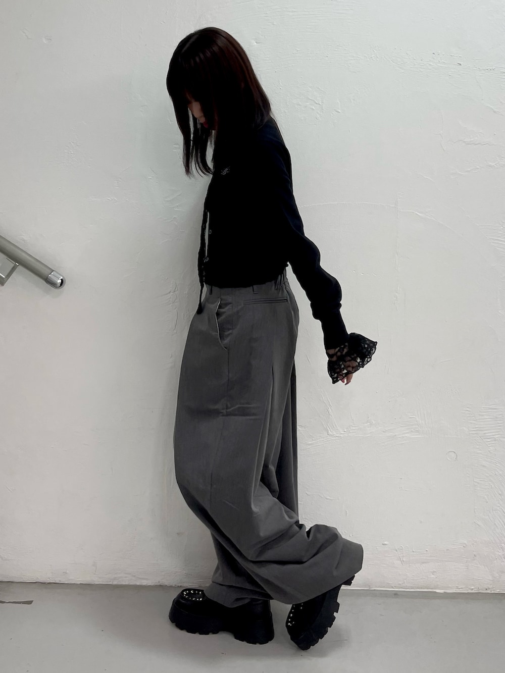 ブラック系のカーディガン/ボレロ、ブラック系のTシャツ/カットソー、グレー系のスラックスを着用したレディースの冬コーディネートの3枚目の写真