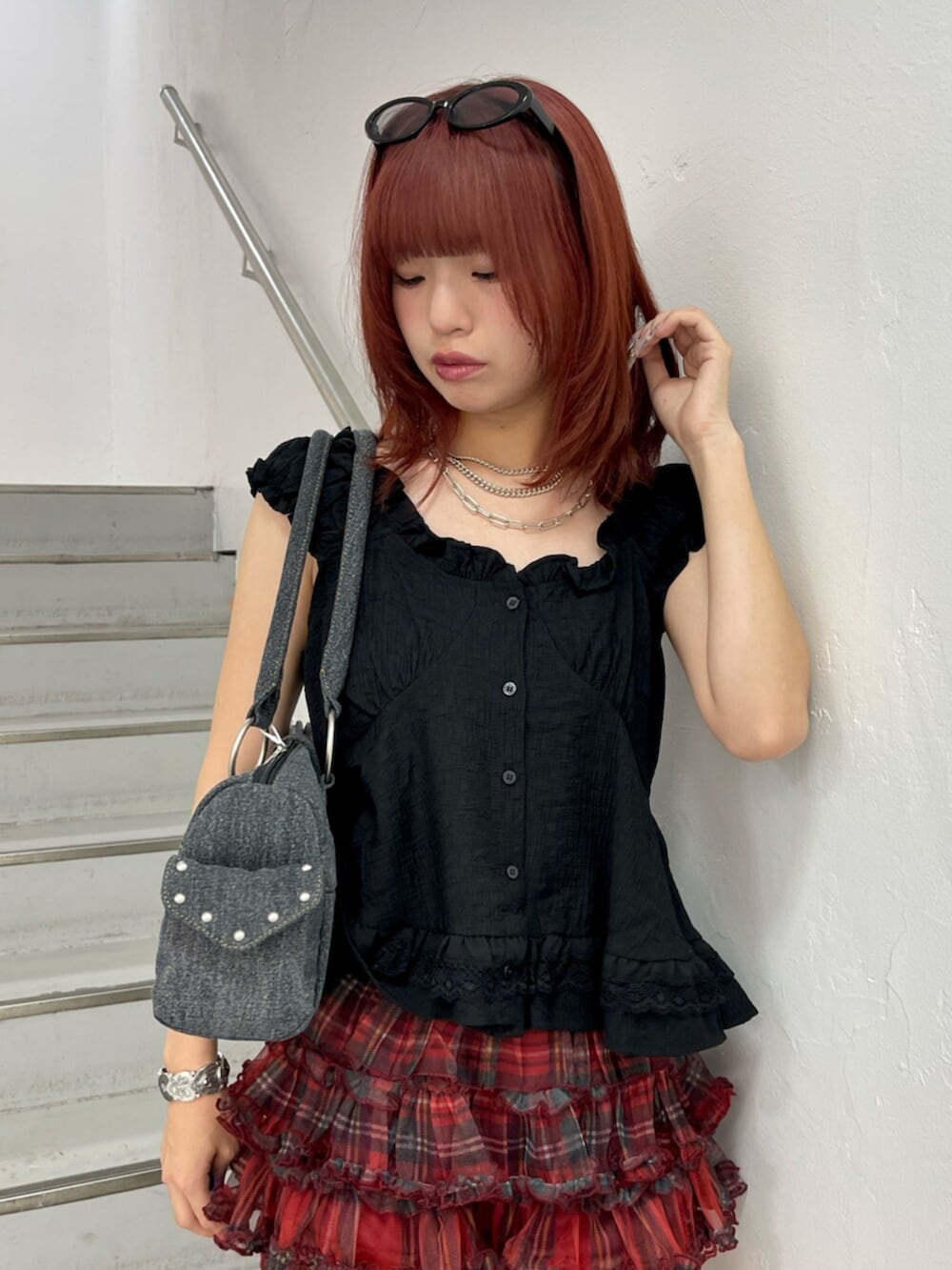 レッド系のその他パンツ、ブラック系のブーツ、ブラック系のボストンバッグを着用したレディースの夏コーディネートの5枚目の写真