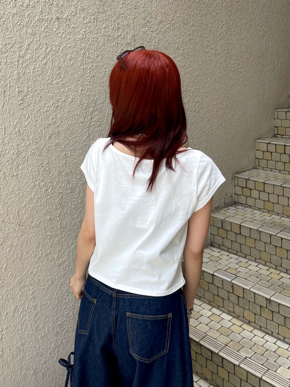ブルー系のデニムパンツ、ホワイト系のTシャツ/カットソー、ブラック系のパンプスを着用したレディースの春コーディネートの7枚目の写真
