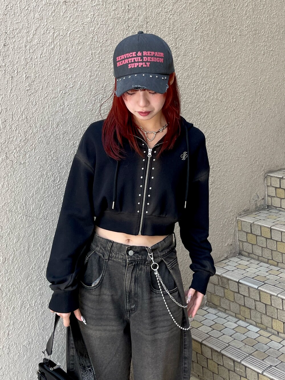 ブラック系のパーカー、ブラック系のデニムパンツ、ブラック系のハンドバッグを着用したレディースの春コーディネートの5枚目の写真
