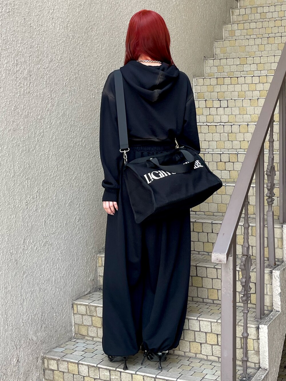 ブラック系のパーカー、ブラック系のスウェットパンツ、ブラック系のボストンバッグを着用したレディースの春コーディネートの4枚目の写真
