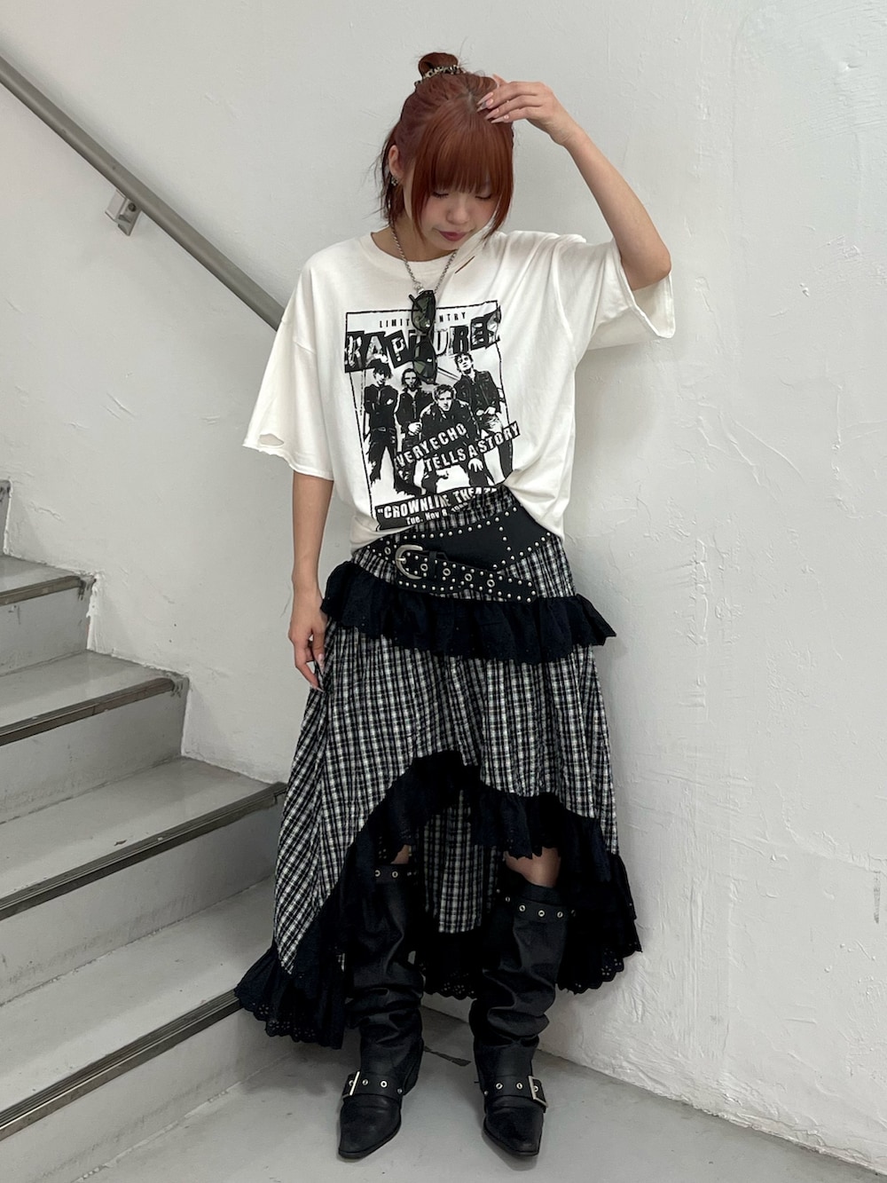 ブラック系のスカート、ブラック系のブーツ、ホワイト系のTシャツ/カットソーを着用したレディースの春コーディネートの2枚目の写真