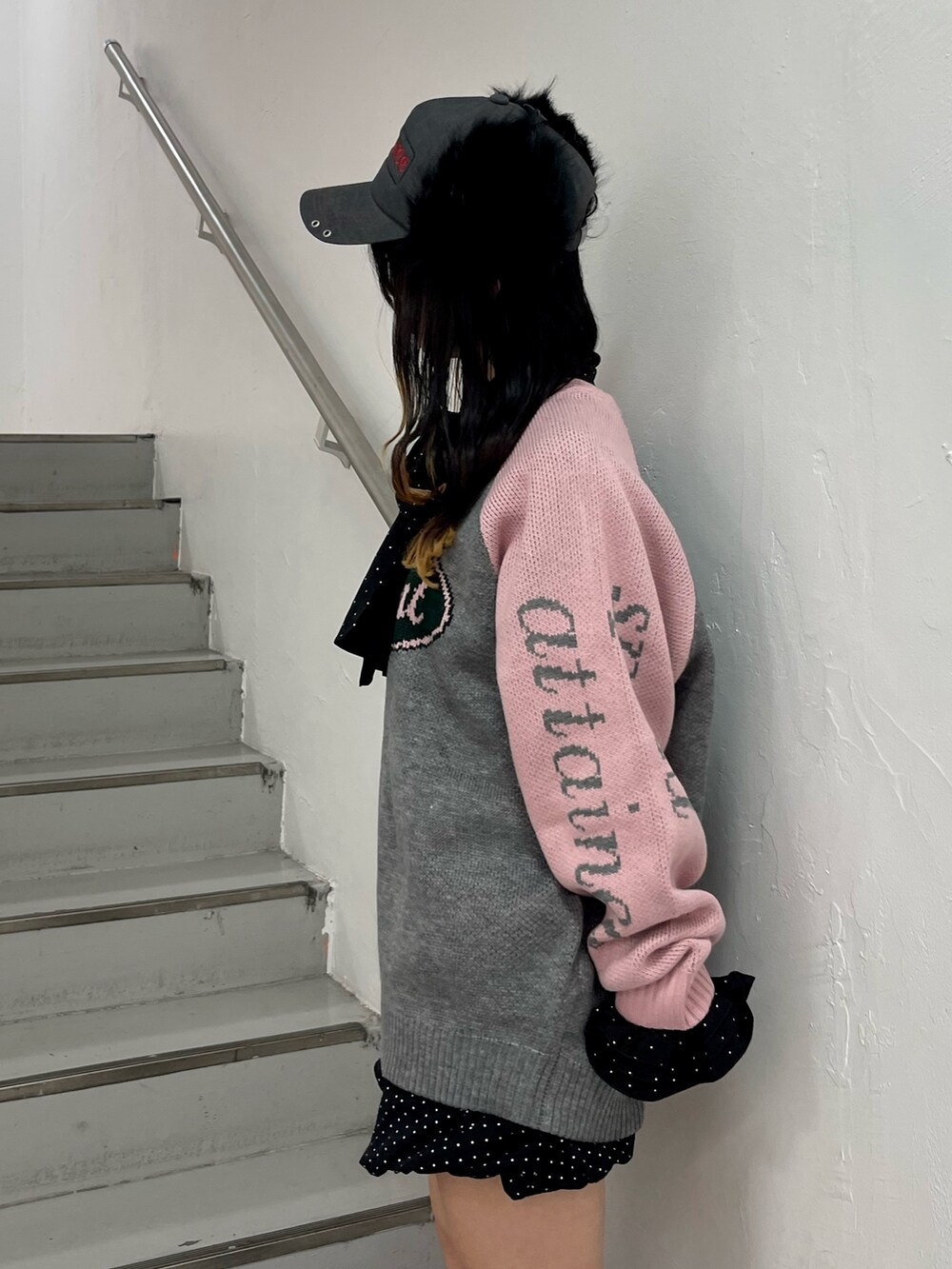 ホワイト系のシャツ/ブラウス、グレー系のニット/セーター、ブラック系のスカートを着用したレディースの秋コーディネートの5枚目の写真