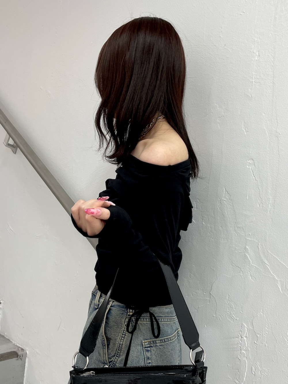 ブラック系のTシャツ/カットソー、ブルー系のデニムパンツ、ブラック系のハンドバッグを着用したレディースの冬コーディネートの6枚目の写真