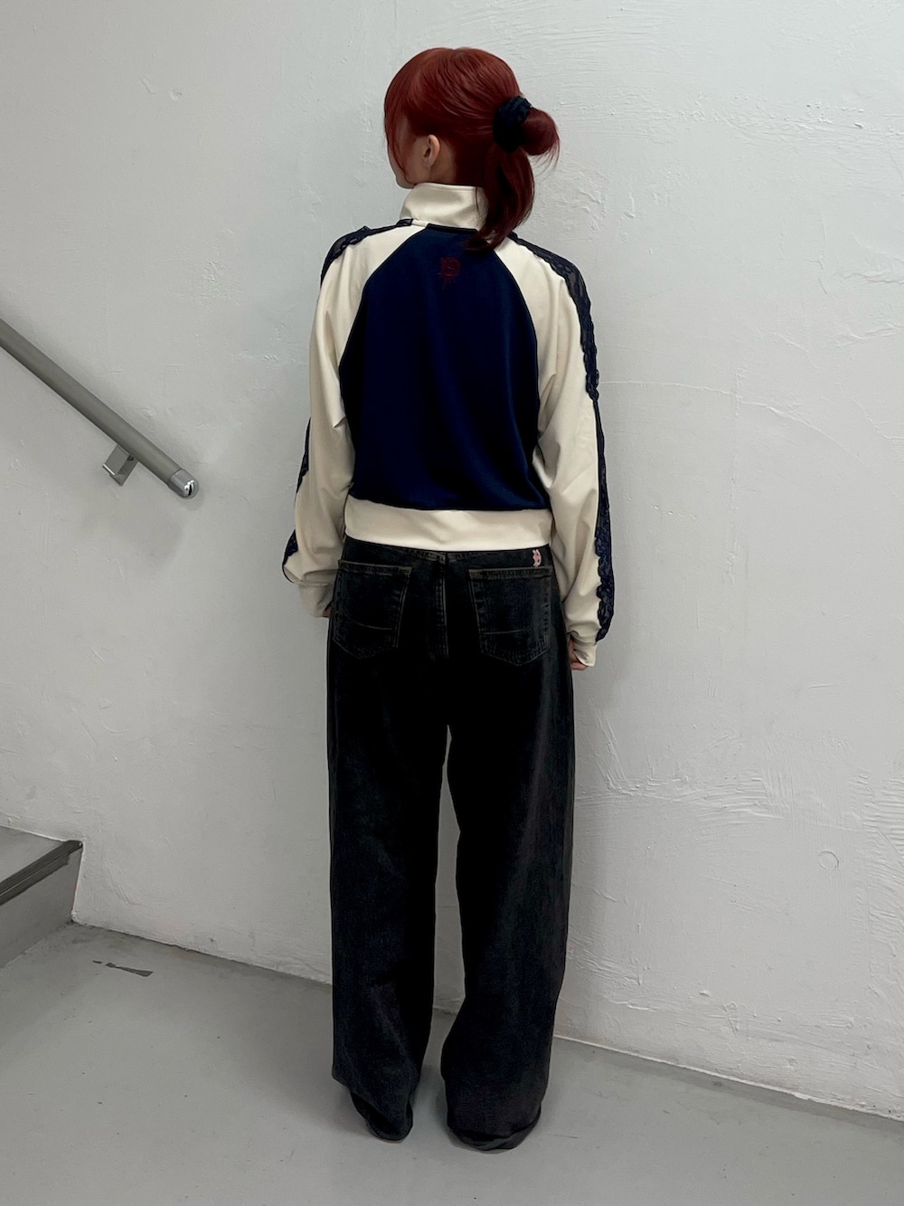 ブラック系のデニムパンツ、ブラック系のパンプス、ブルー系のジャージを着用したレディースの春コーディネートの4枚目の写真