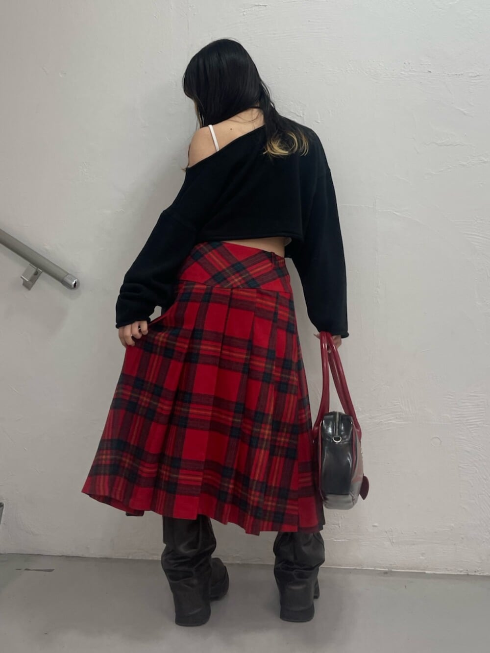 ブラック系のボストンバッグ、ブラック系のブーツ、ブラック系のニット/セーターを着用したレディースの秋コーディネートの3枚目の写真