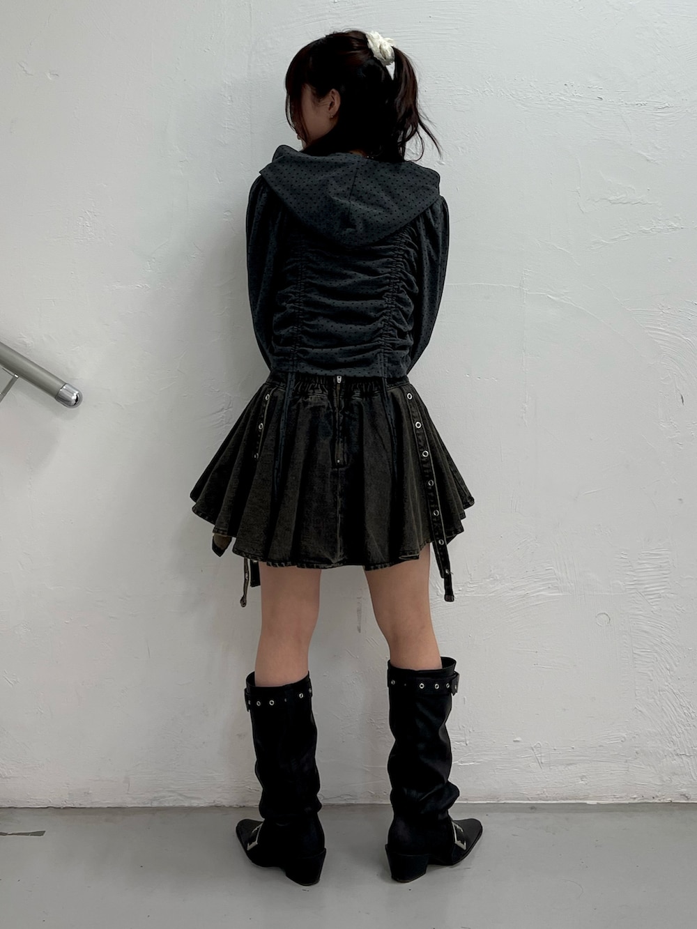 ブラック系のパーカー、ブラック系のデニムスカート、ブラック系のブーツを着用したレディースの春コーディネートの4枚目の写真