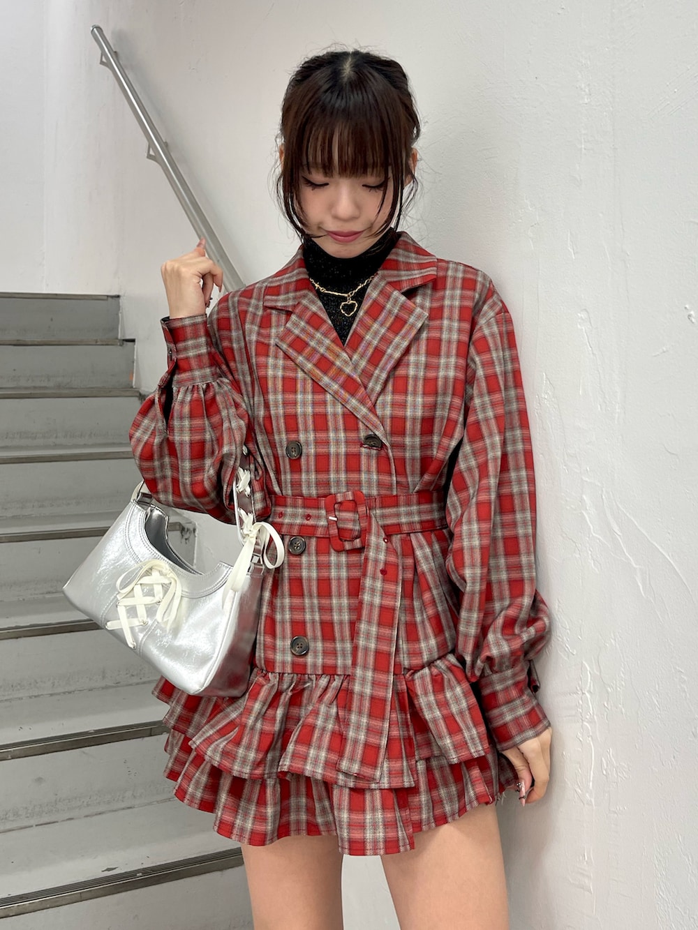 レッド系のワンピース、シルバー系のハンドバッグ、ブラック系のニット/セーターを着用したレディースの冬コーディネートの5枚目の写真