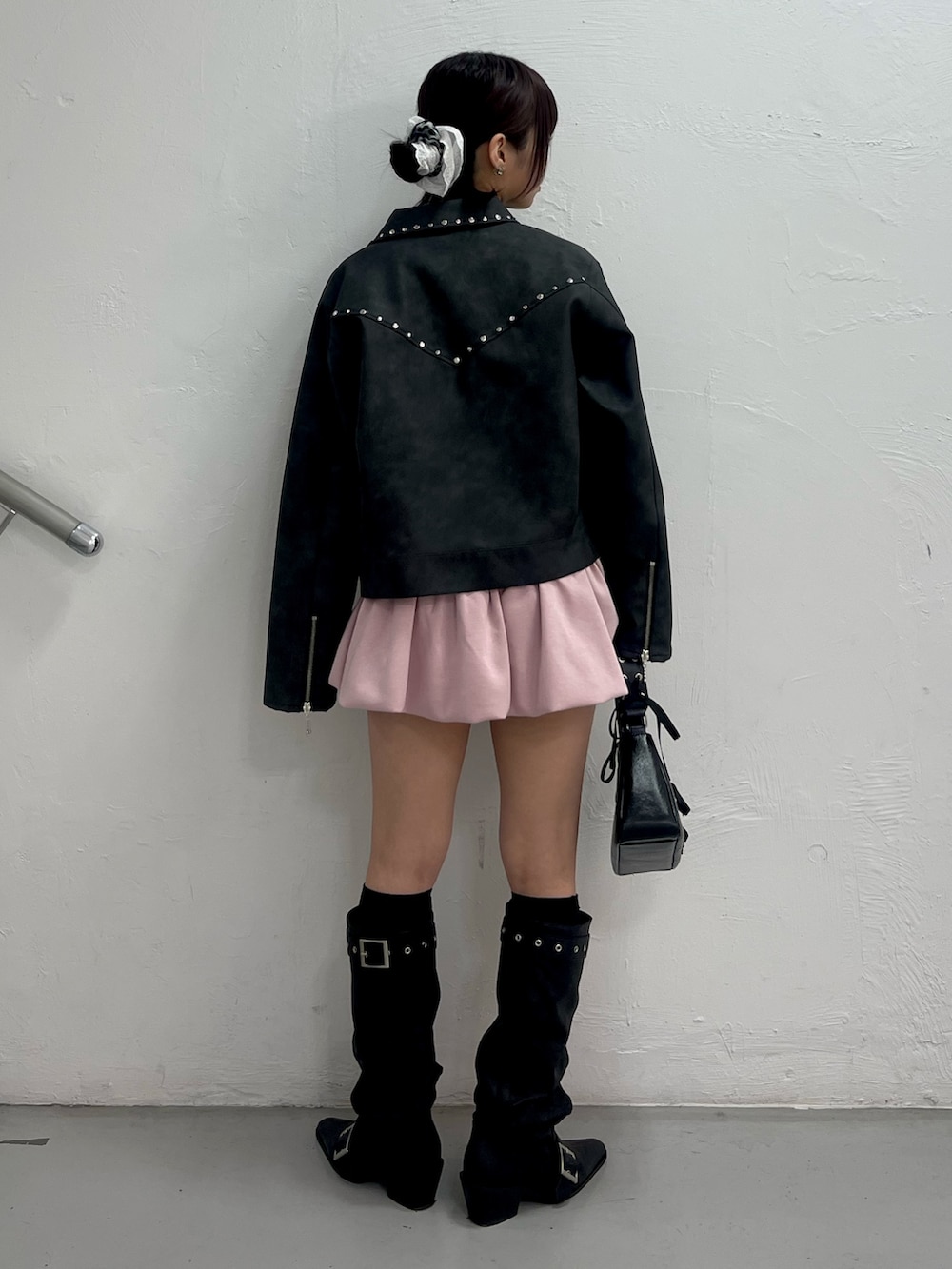 ブラック系のブルゾン、ホワイト系のTシャツ/カットソー、ピンク系のスカートを着用したレディースの冬コーディネートの4枚目の写真