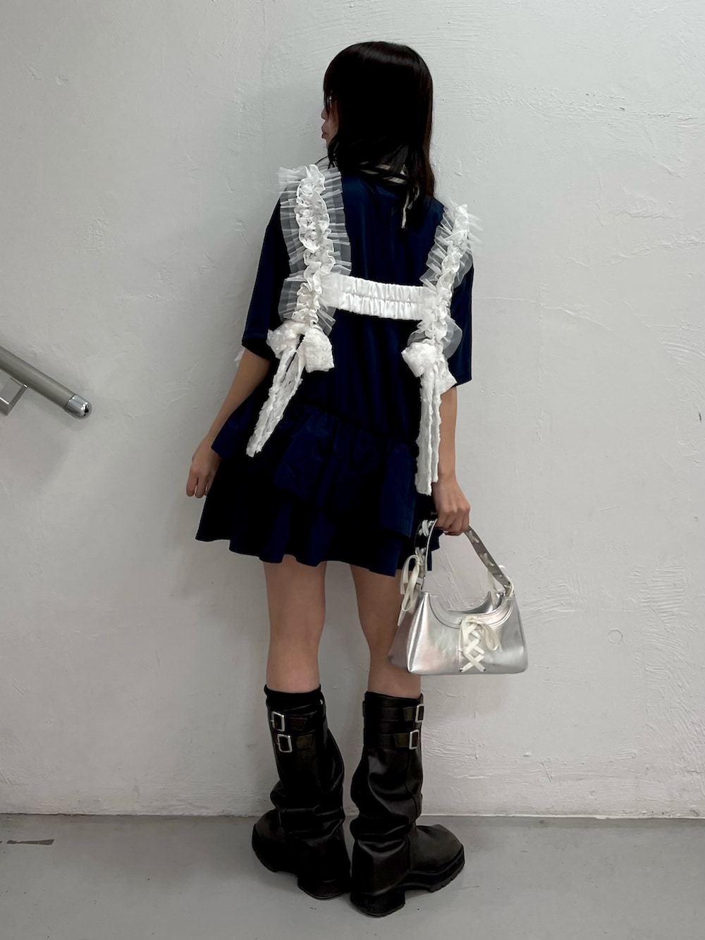 ブルー系のワンピース、シルバー系のハンドバッグ、ホワイト系のベルトを着用したレディースの冬コーディネートの4枚目の写真