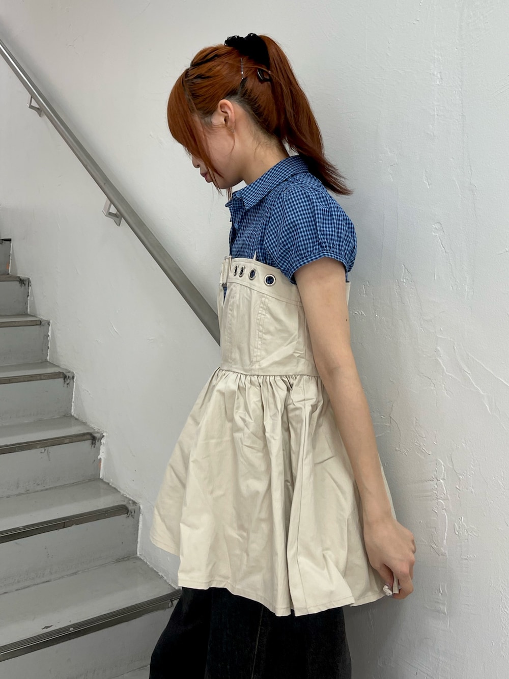 ホワイト系のチュニック、ブラック系のデニムパンツ、ブラック系のパンプスを着用したレディースの春コーディネートの6枚目の写真