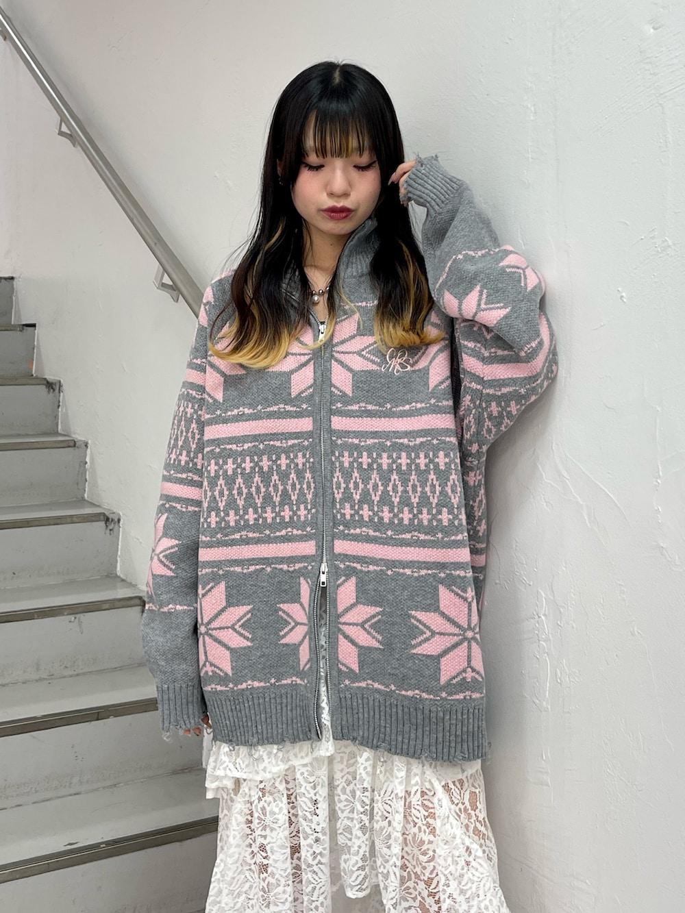 ホワイト系のステンカラーコート、グレー系のカーディガン/ボレロ、ホワイト系のスカートを着用したレディースの秋コーディネートの6枚目の写真