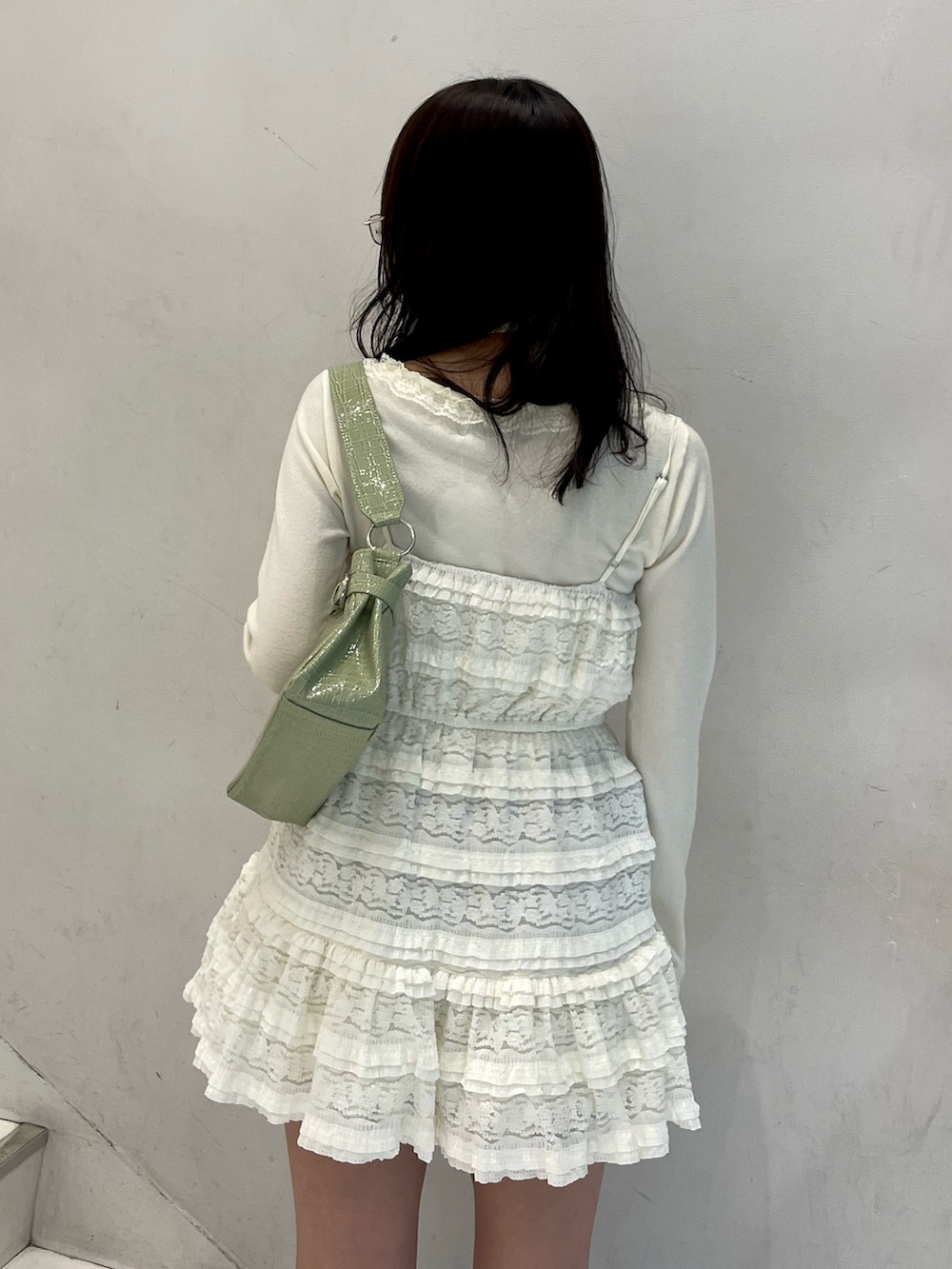 ホワイト系のワンピース、ホワイト系のニット/セーター、グリーン系のハンドバッグを着用したレディースの冬コーディネートの7枚目の写真