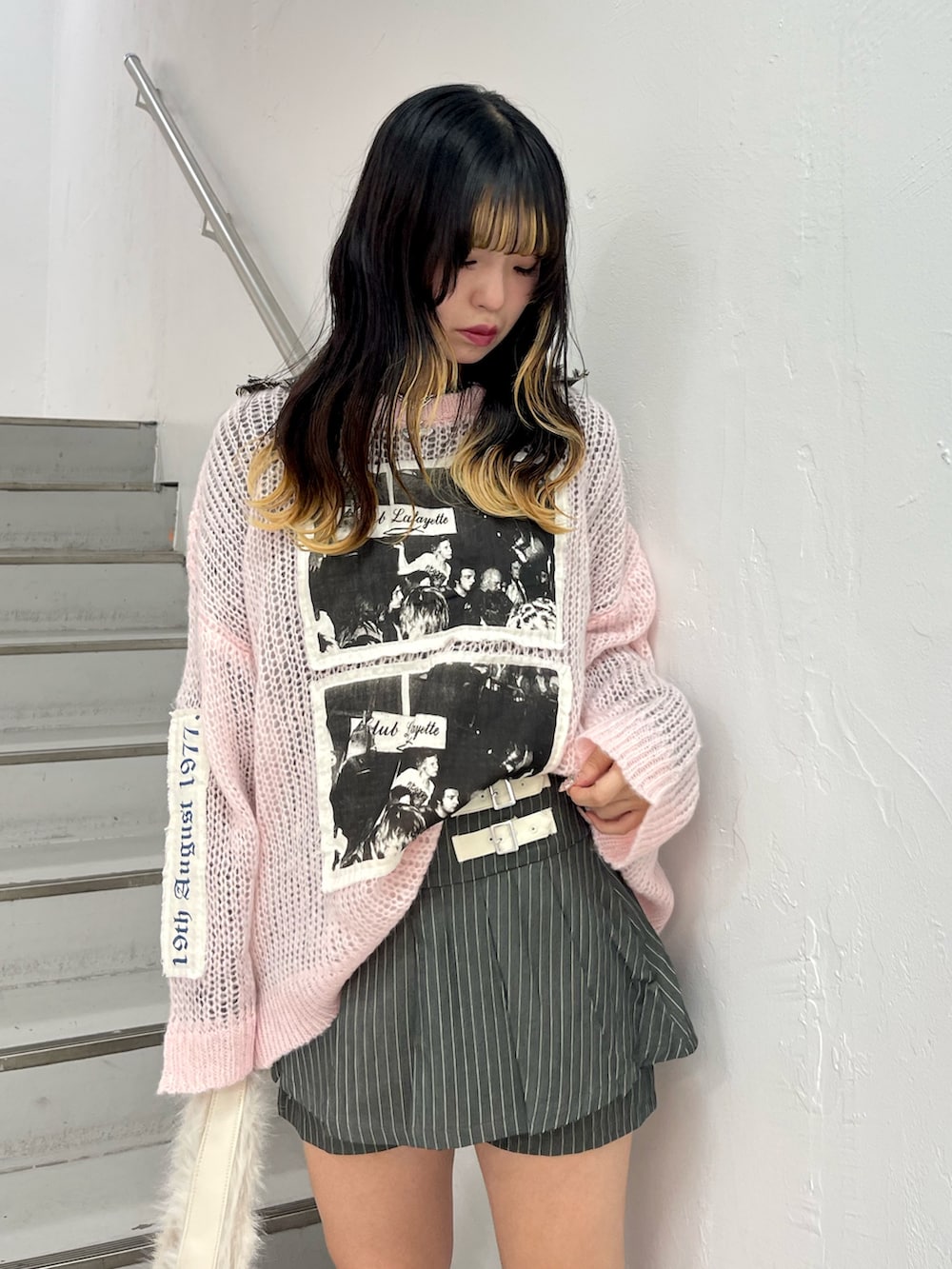 ピンク系のニット/セーター、グレー系のスカート、ブラック系のニット/セーターを着用したレディースの秋コーディネートの4枚目の写真