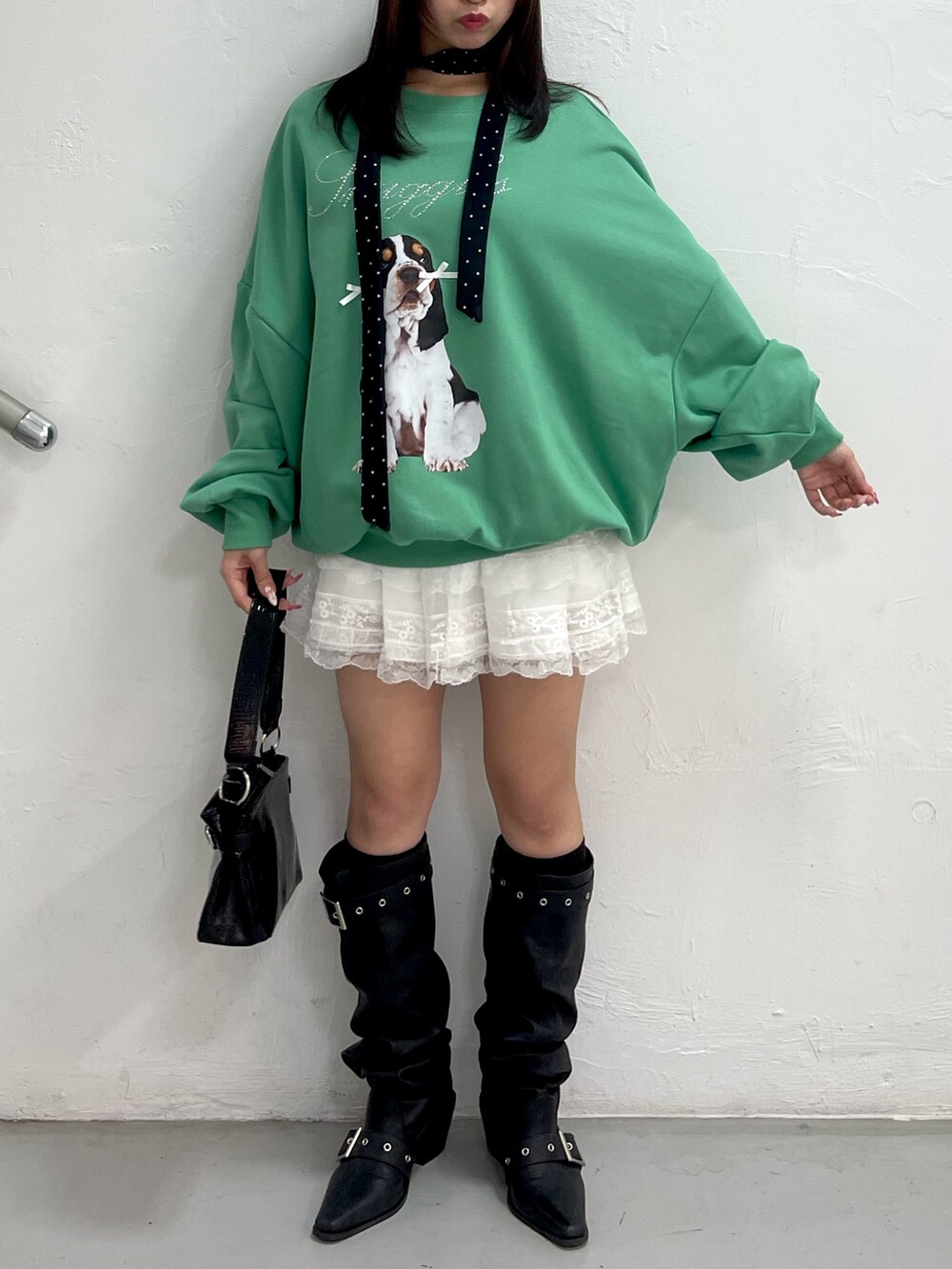 グリーン系のスウェット、ホワイト系のその他パンツ、ブラック系のハンドバッグを着用したレディースの冬コーディネートの2枚目の写真