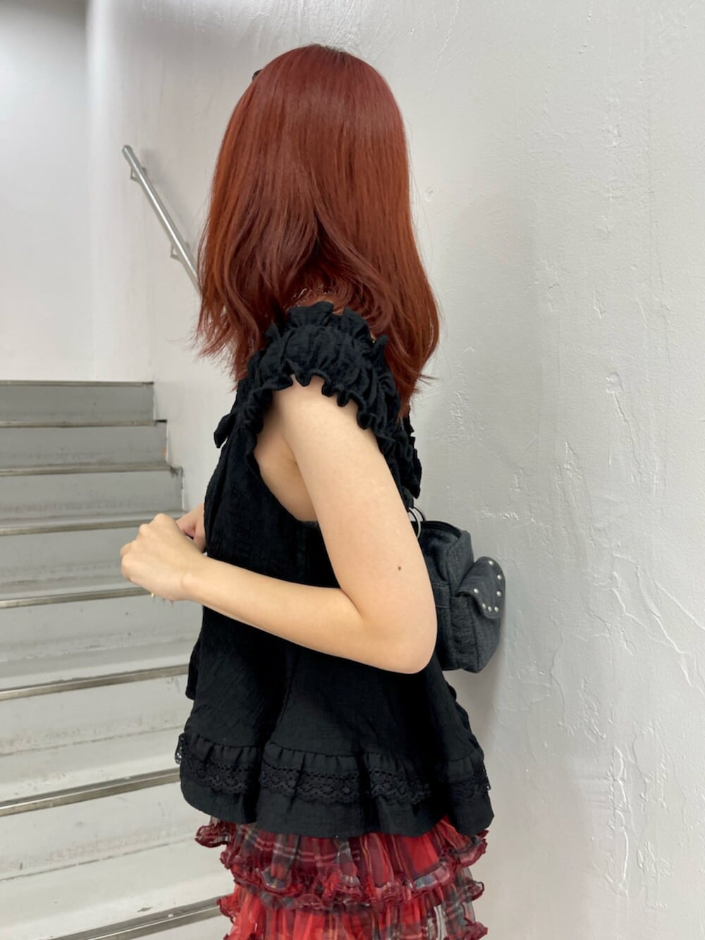 レッド系のその他パンツ、ブラック系のブーツ、ブラック系のボストンバッグを着用したレディースの夏コーディネートの6枚目の写真