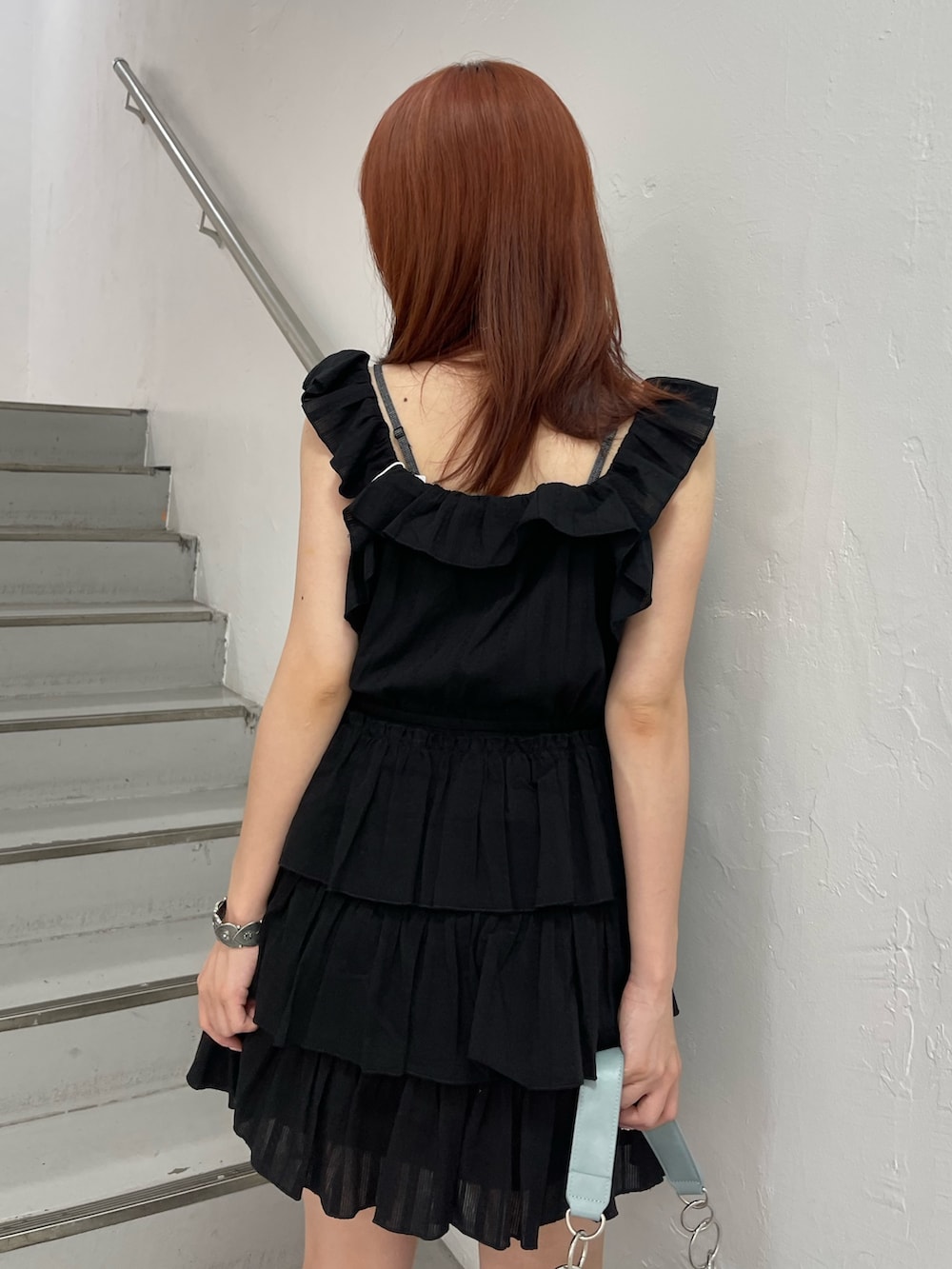 ブラック系のワンピース、ブルー系のハンドバッグ、ブラック系のブーツを着用したレディースの夏コーディネートの7枚目の写真