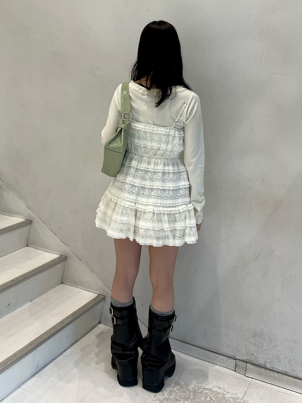 ホワイト系のワンピース、ホワイト系のニット/セーター、グリーン系のハンドバッグを着用したレディースの冬コーディネートの4枚目の写真