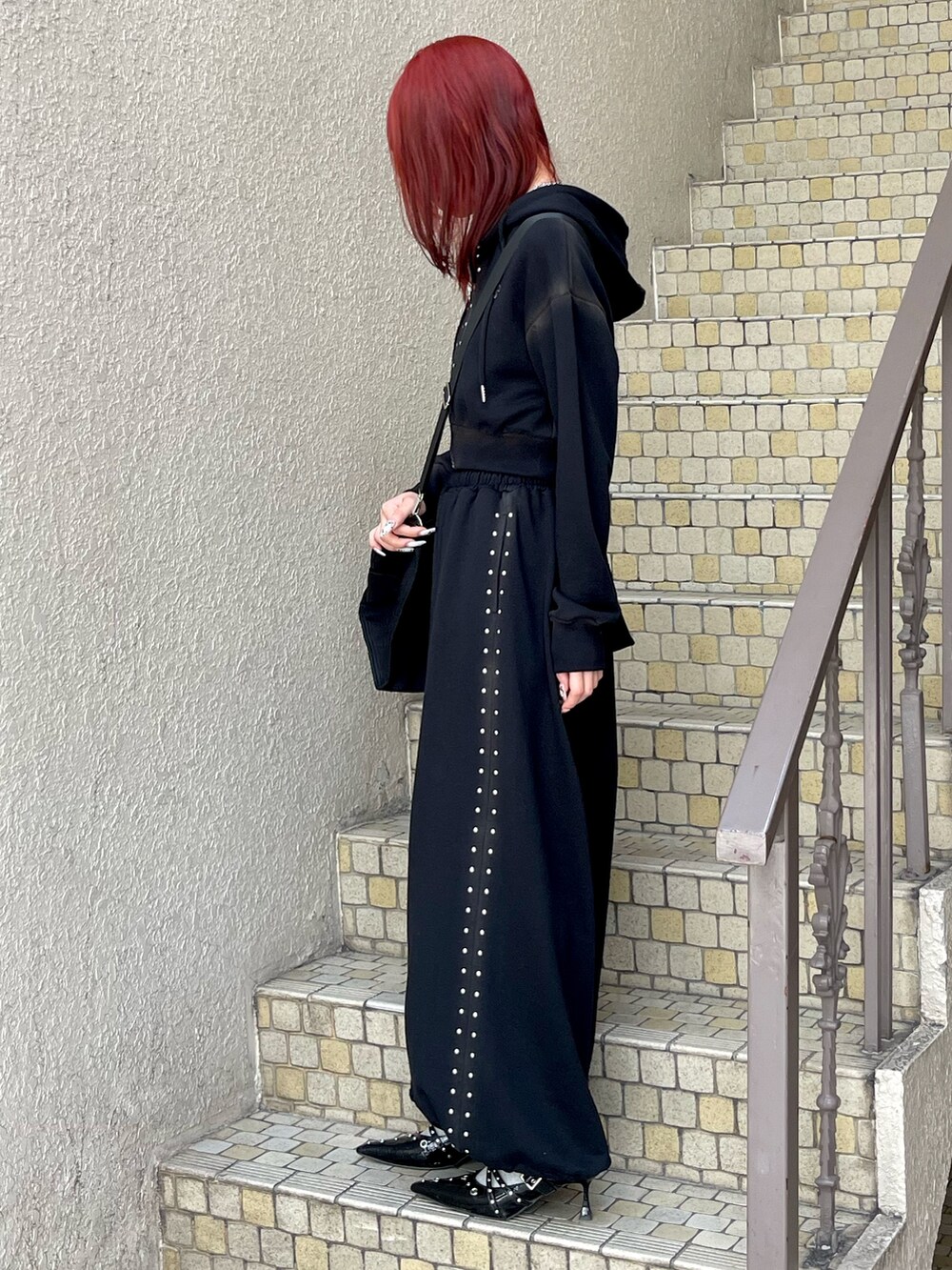 ブラック系のパーカー、ブラック系のスウェットパンツ、ブラック系のボストンバッグを着用したレディースの春コーディネートの3枚目の写真