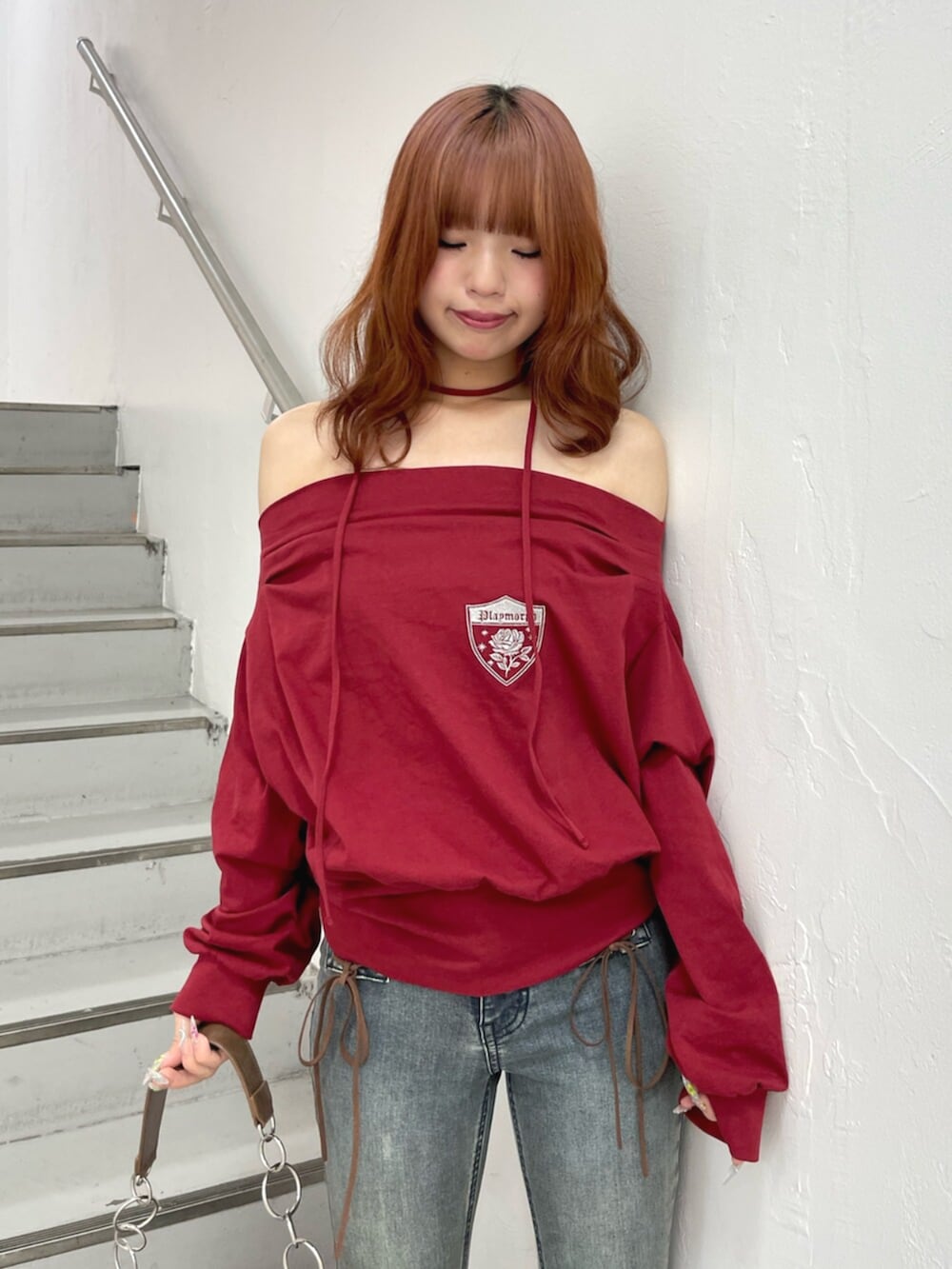 ブラック系のパンプス、ブラウン系のハンドバッグ、レッド系のTシャツ/カットソーを着用したレディースの夏コーディネートの5枚目の写真
