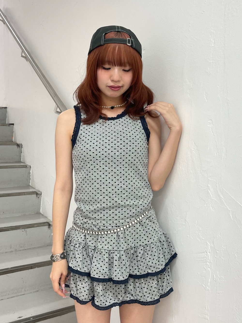 グレー系のスカート、グレー系のタンクトップ、ブラック系のブーツを着用したレディースの夏コーディネートの5枚目の写真