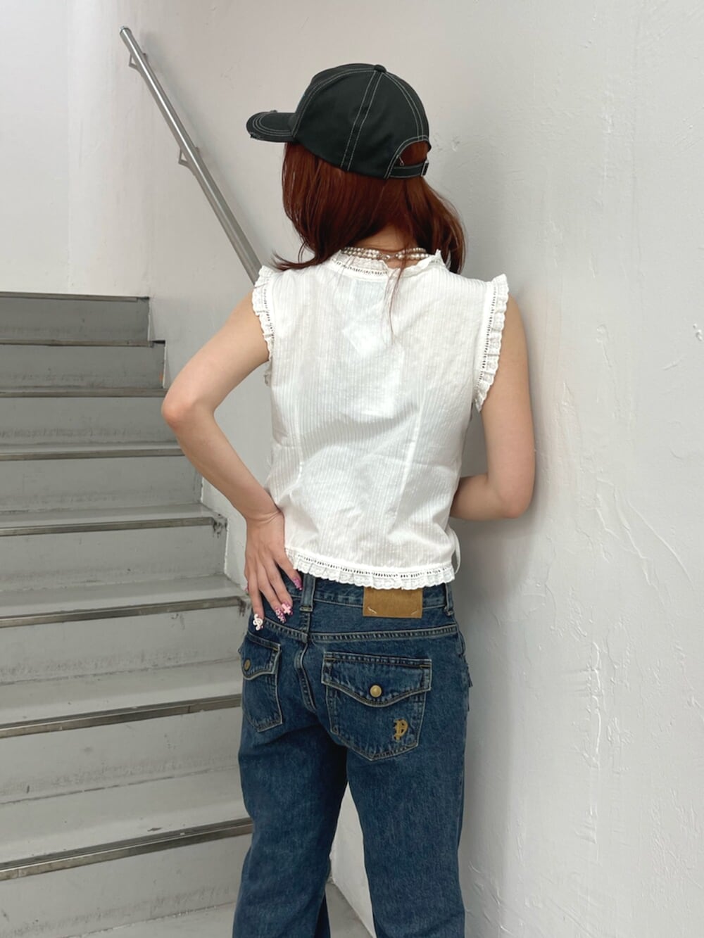 ブラック系のパンプス、ブルー系のデニムパンツ、ホワイト系のシャツ/ブラウスを着用したレディースの夏コーディネートの7枚目の写真