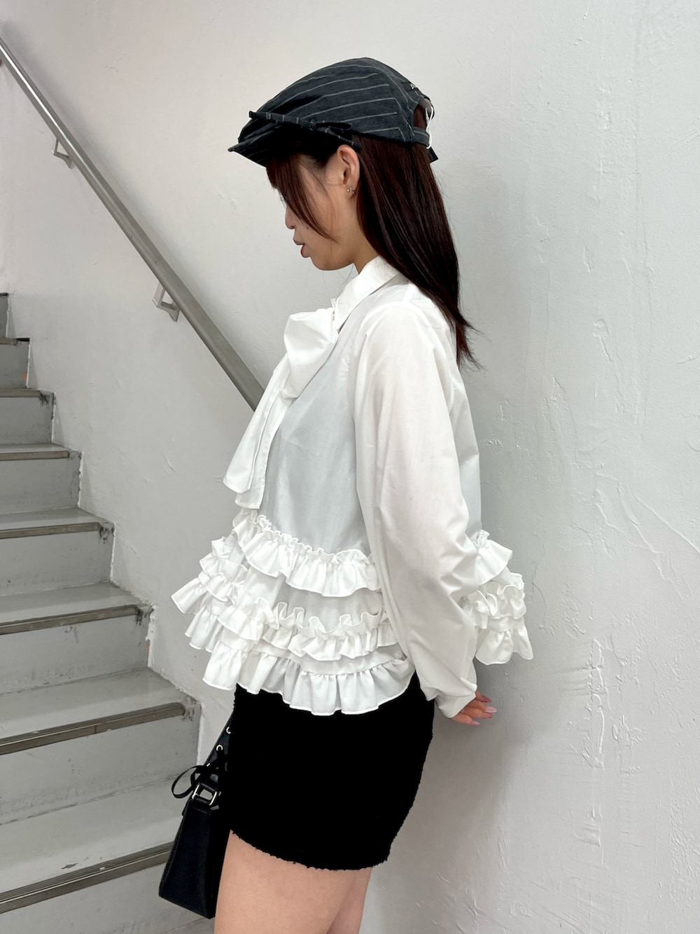 ホワイト系のシャツ/ブラウス、ブラック系のハンドバッグ、ブラック系のブーツを着用したレディースの冬コーディネートの6枚目の写真