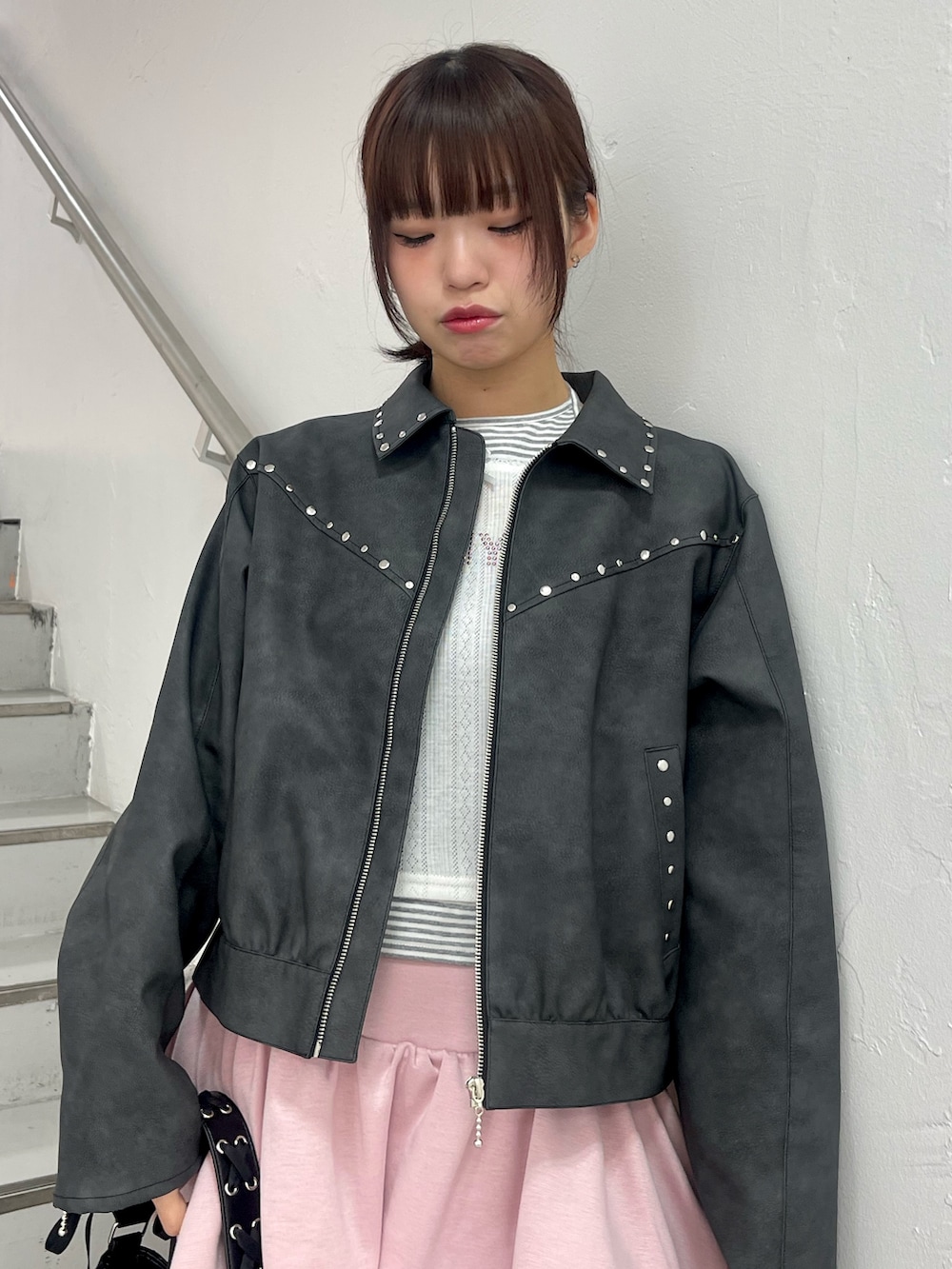 ブラック系のブルゾン、ホワイト系のTシャツ/カットソー、ピンク系のスカートを着用したレディースの冬コーディネートの5枚目の写真