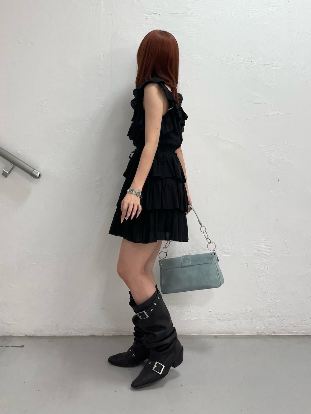 ブラック系のワンピース、ブルー系のハンドバッグ、ブラック系のブーツを着用したレディースの夏コーディネートの3枚目の写真
