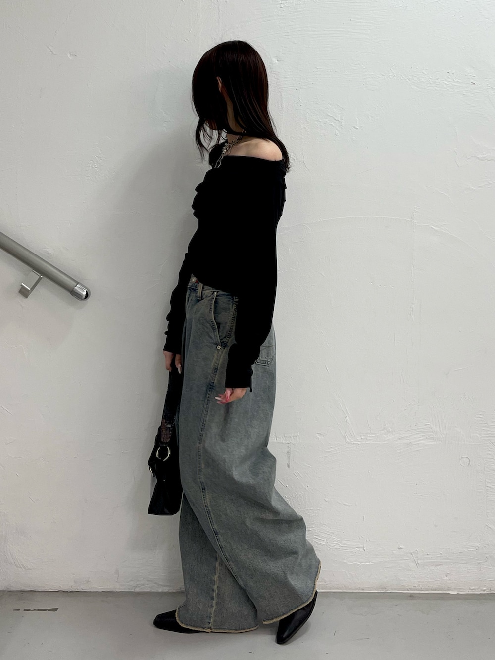 ブラック系のTシャツ/カットソー、ブルー系のデニムパンツ、ブラック系のハンドバッグを着用したレディースの冬コーディネートの3枚目の写真