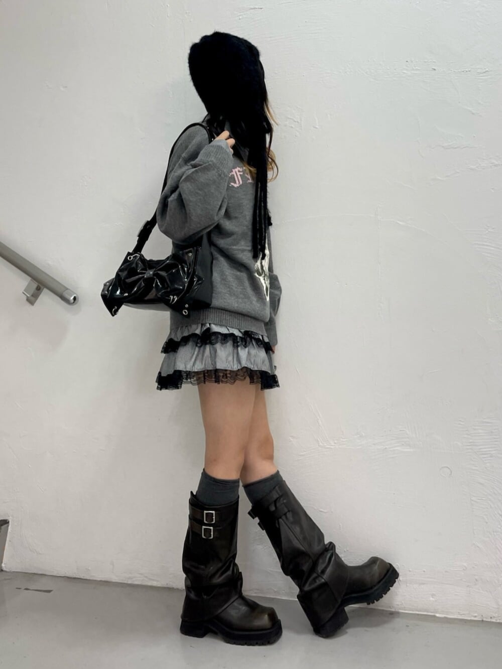 グレー系のニット/セーター、ブラック系のシャツ/ブラウス、ブラック系のブーツを着用したレディースの秋コーディネートの2枚目の写真