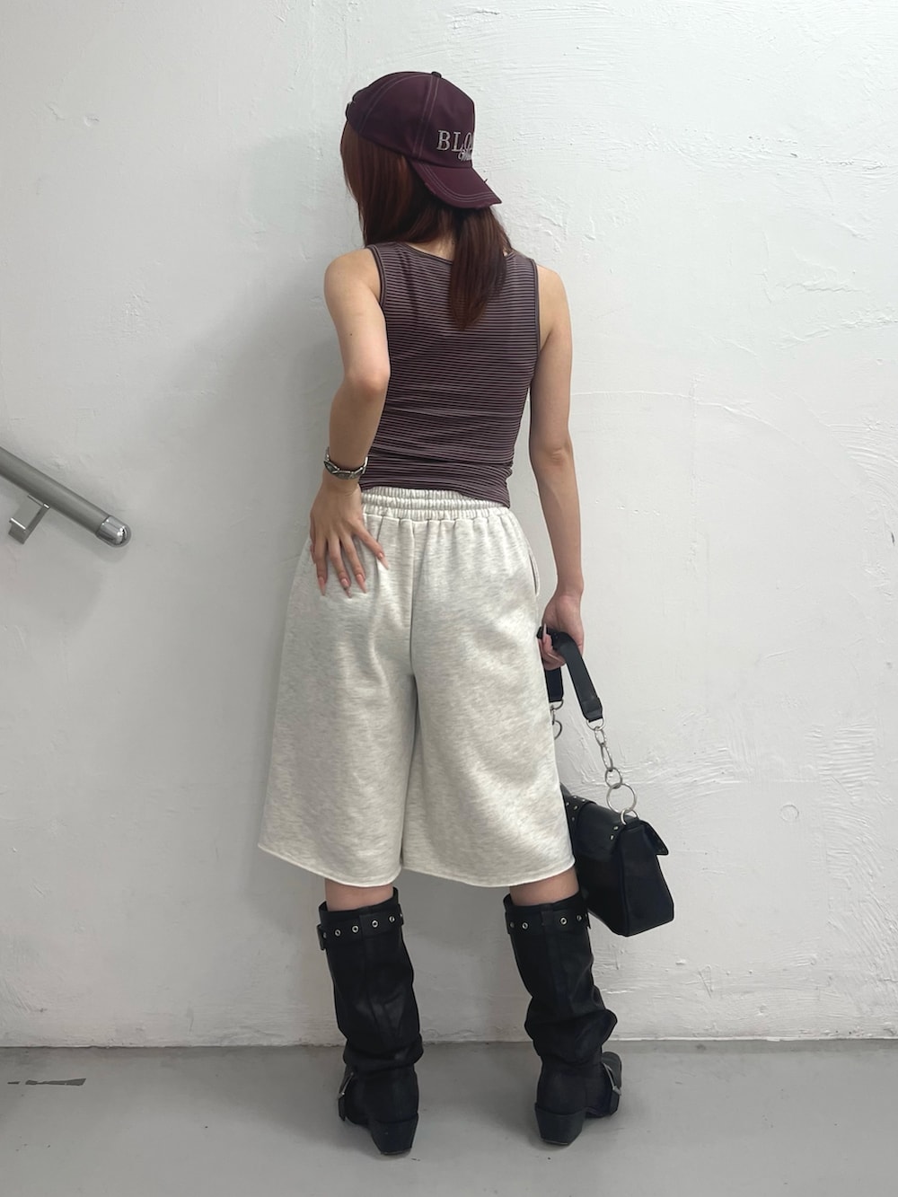 ブラウン系のタンクトップ、ブラック系のハンドバッグ、グレー系のその他パンツを着用したレディースの夏コーディネートの4枚目の写真