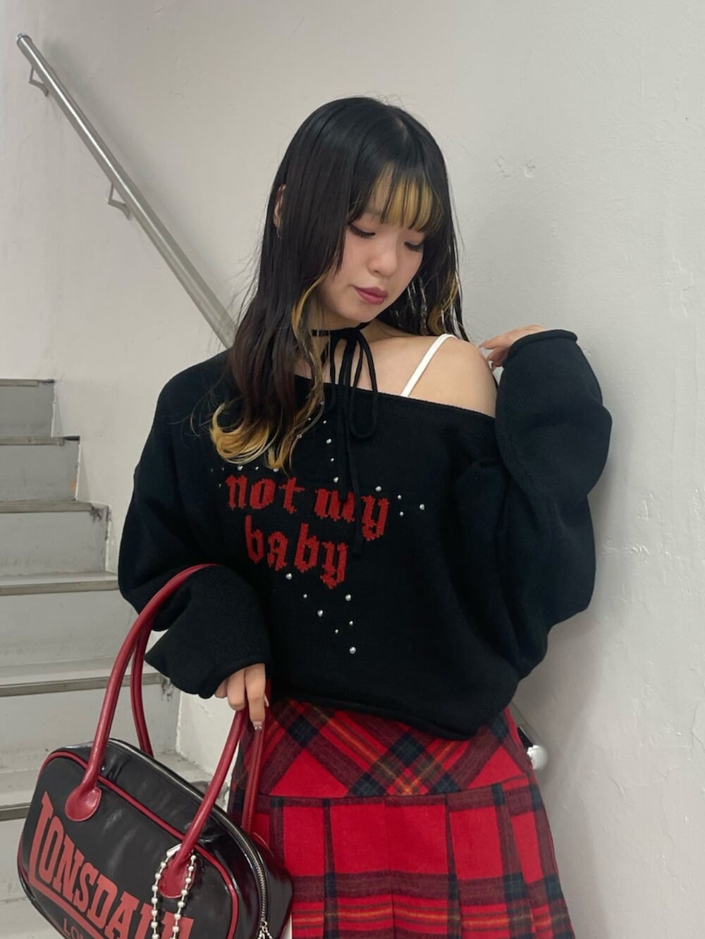 ブラック系のボストンバッグ、ブラック系のブーツ、ブラック系のニット/セーターを着用したレディースの秋コーディネートの4枚目の写真