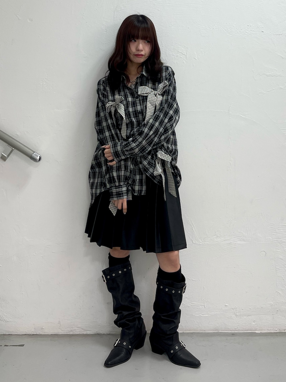 ブラック系のシャツ/ブラウス、ブラック系のスカート、ブラック系のブーツを着用したレディースの春コーディネートの2枚目の写真