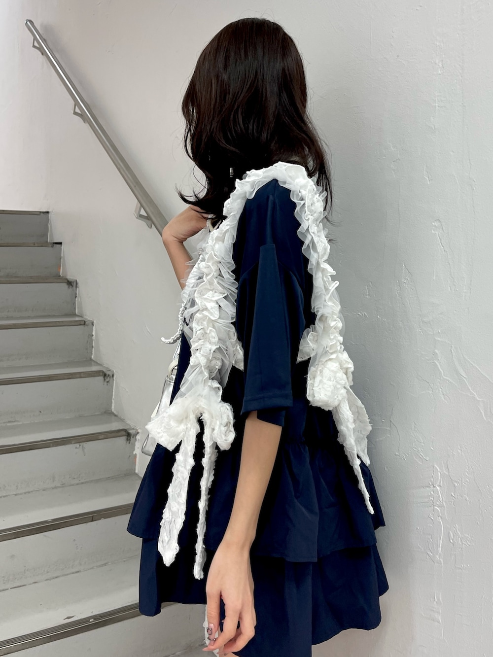 ブルー系のワンピース、シルバー系のハンドバッグ、ホワイト系のベルトを着用したレディースの冬コーディネートの6枚目の写真