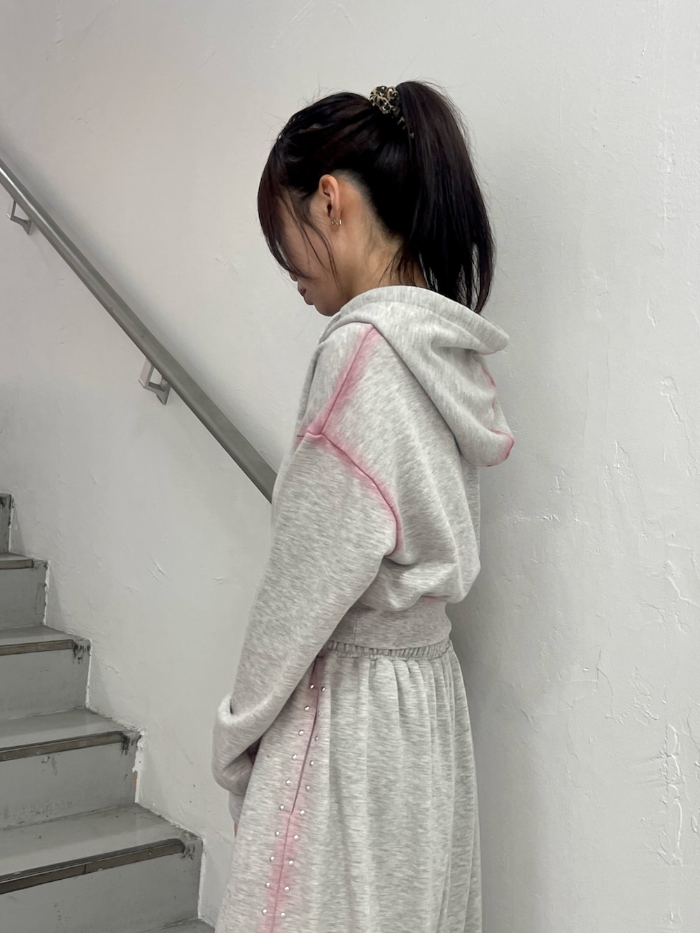 グレー系のスウェットパンツ、グレー系のパーカー、ブラック系のハンドバッグを着用したレディースの春コーディネートの6枚目の写真